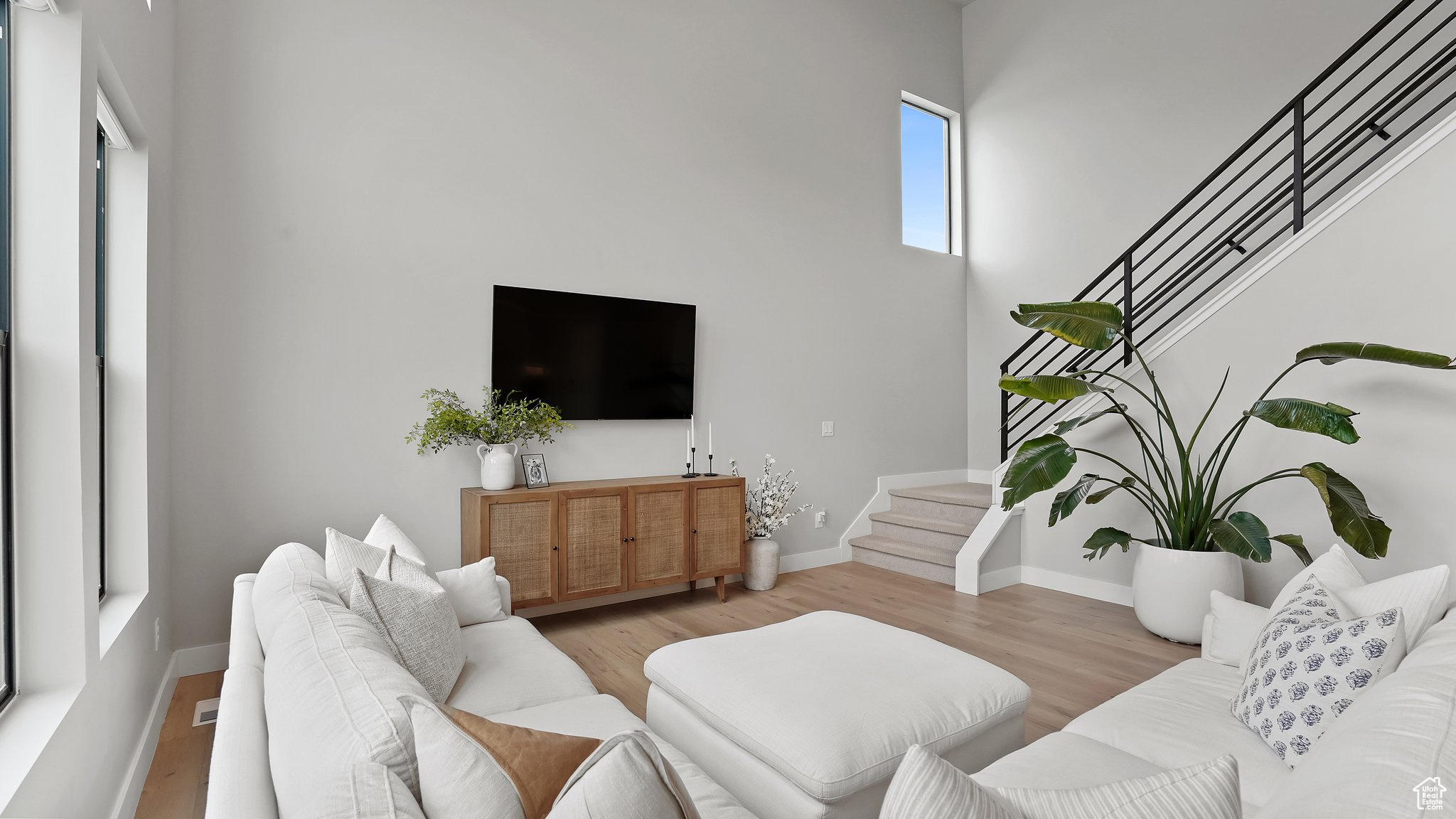 Living room featuring a towering ceiling and hardwood / wood-style floors