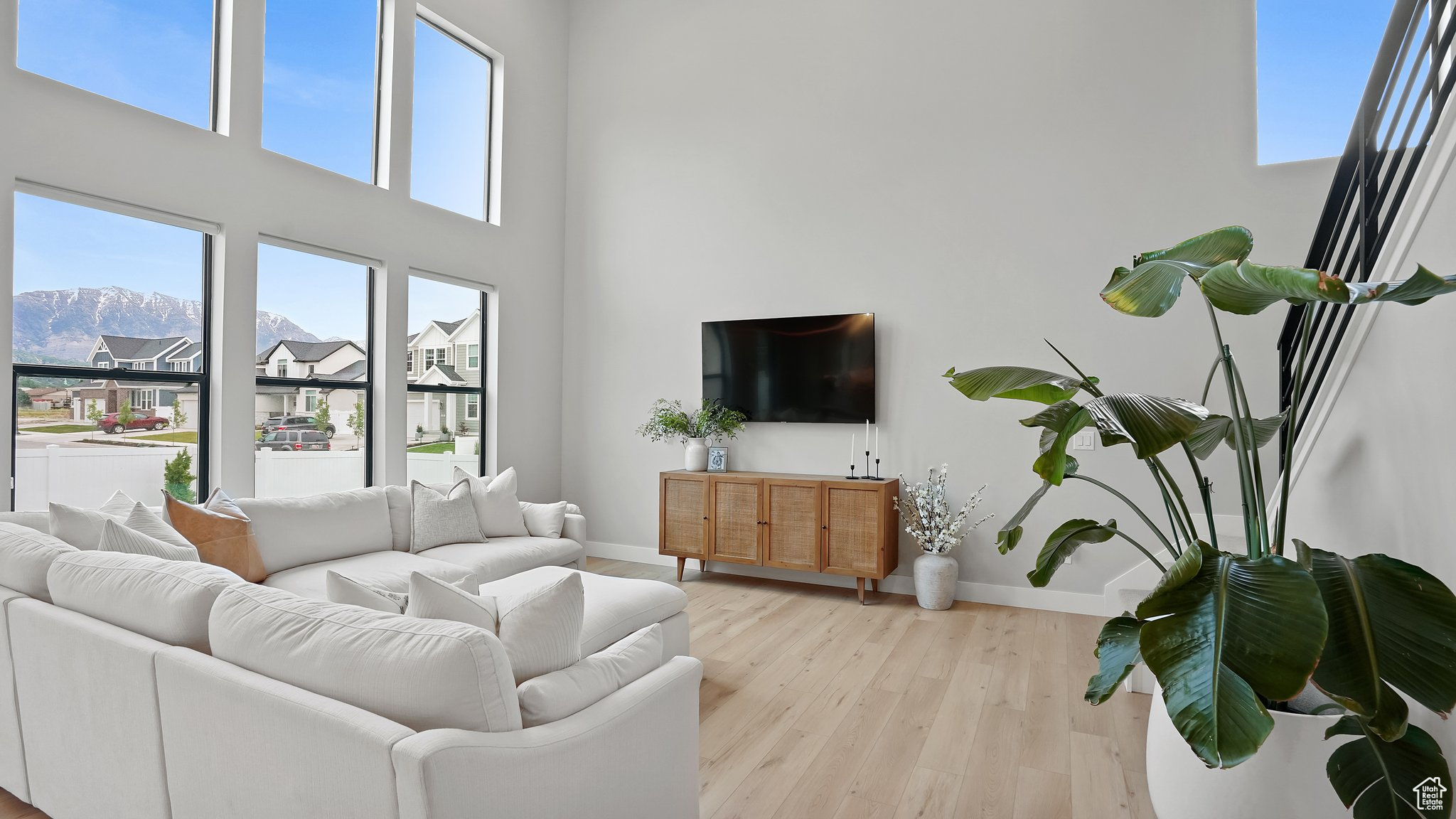 Living room featuring light hardwood / wood-style floors, a healthy amount of sunlight, and a high ceiling