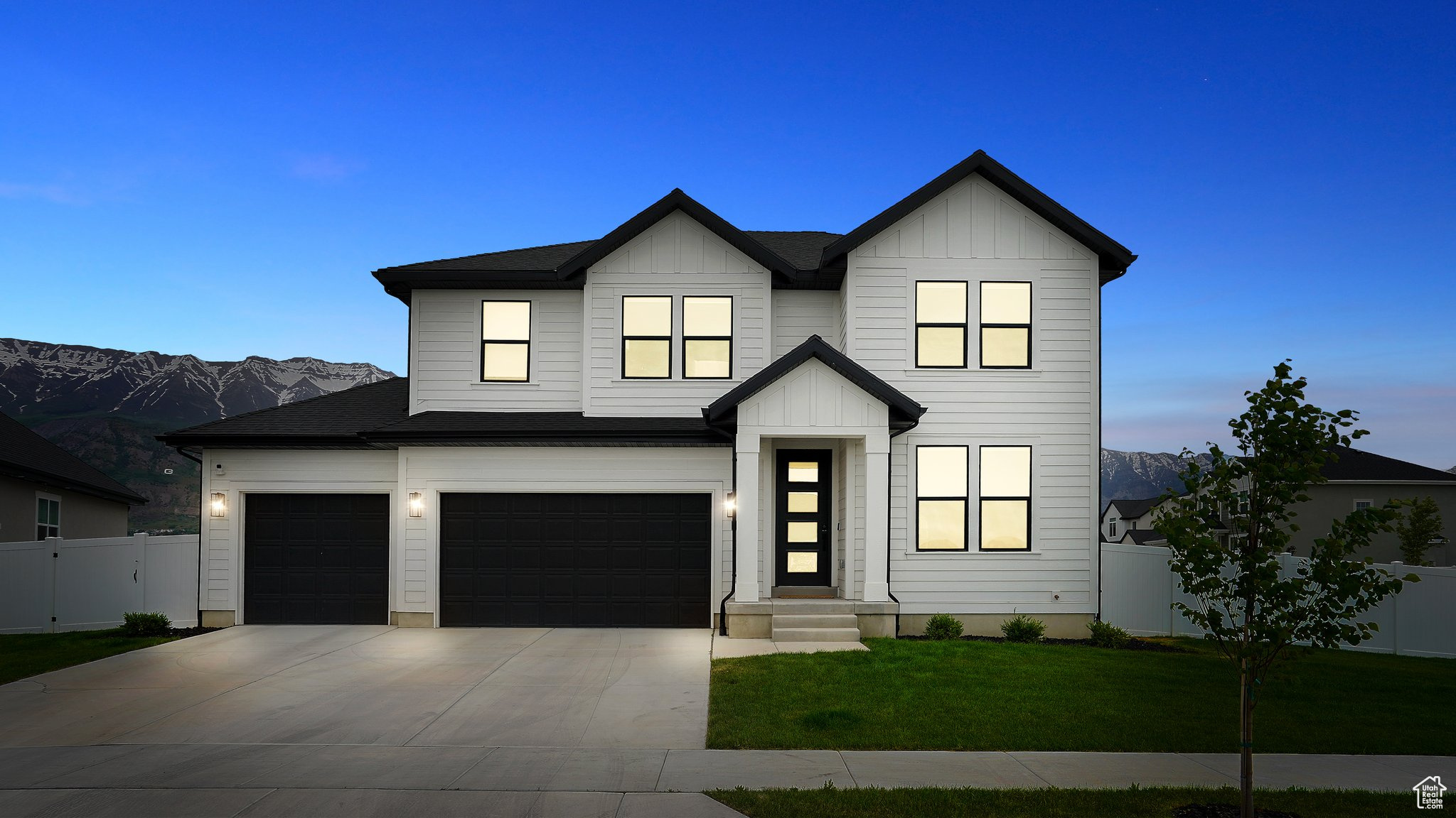 Modern farmhouse with a garage and a lawn