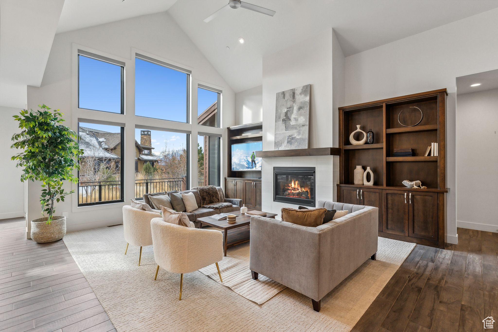 Living room featuring ceiling fan, high vaulted ceiling, and light wood-type flooring