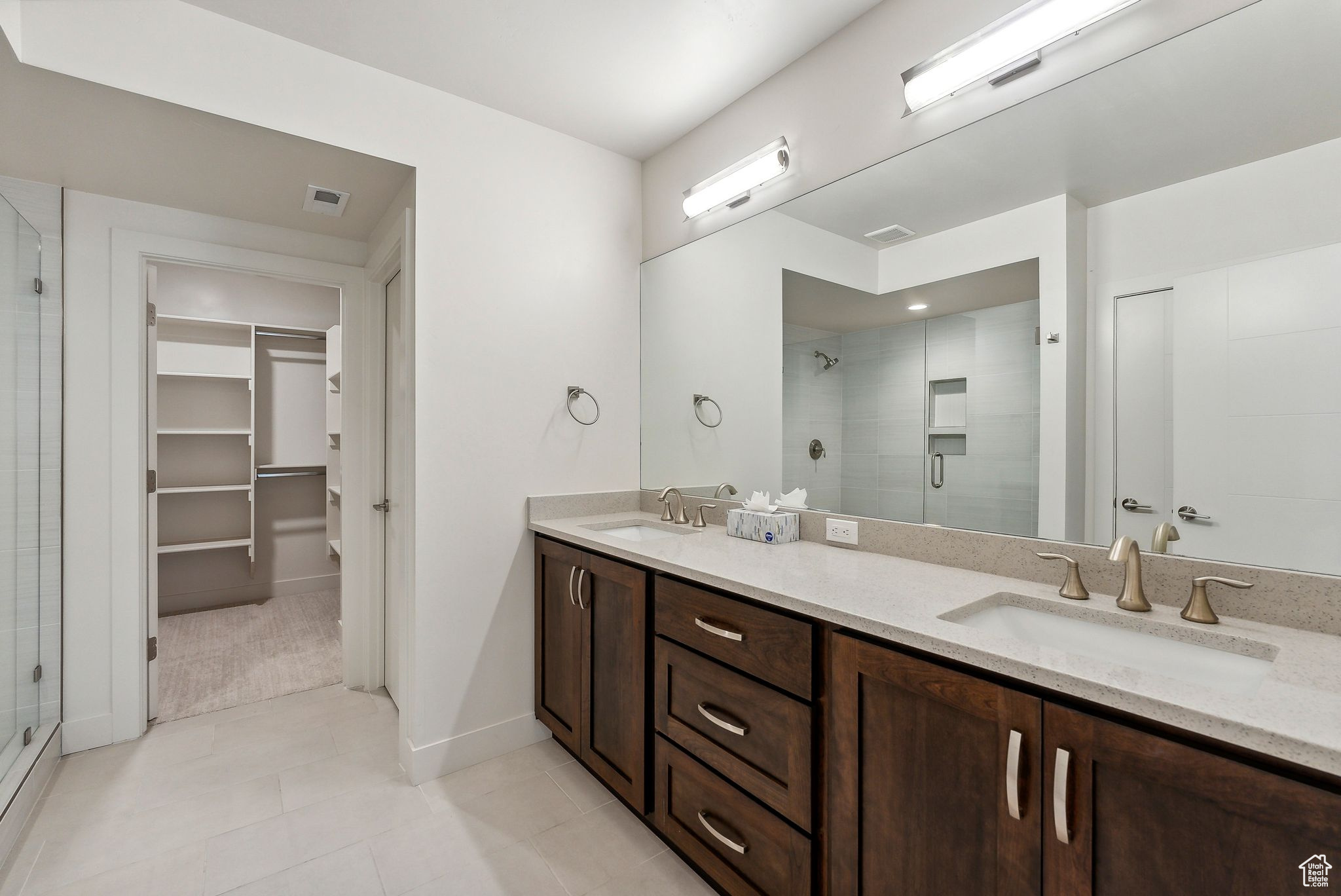 Bathroom featuring tile patterned floors, vanity, and an enclosed shower