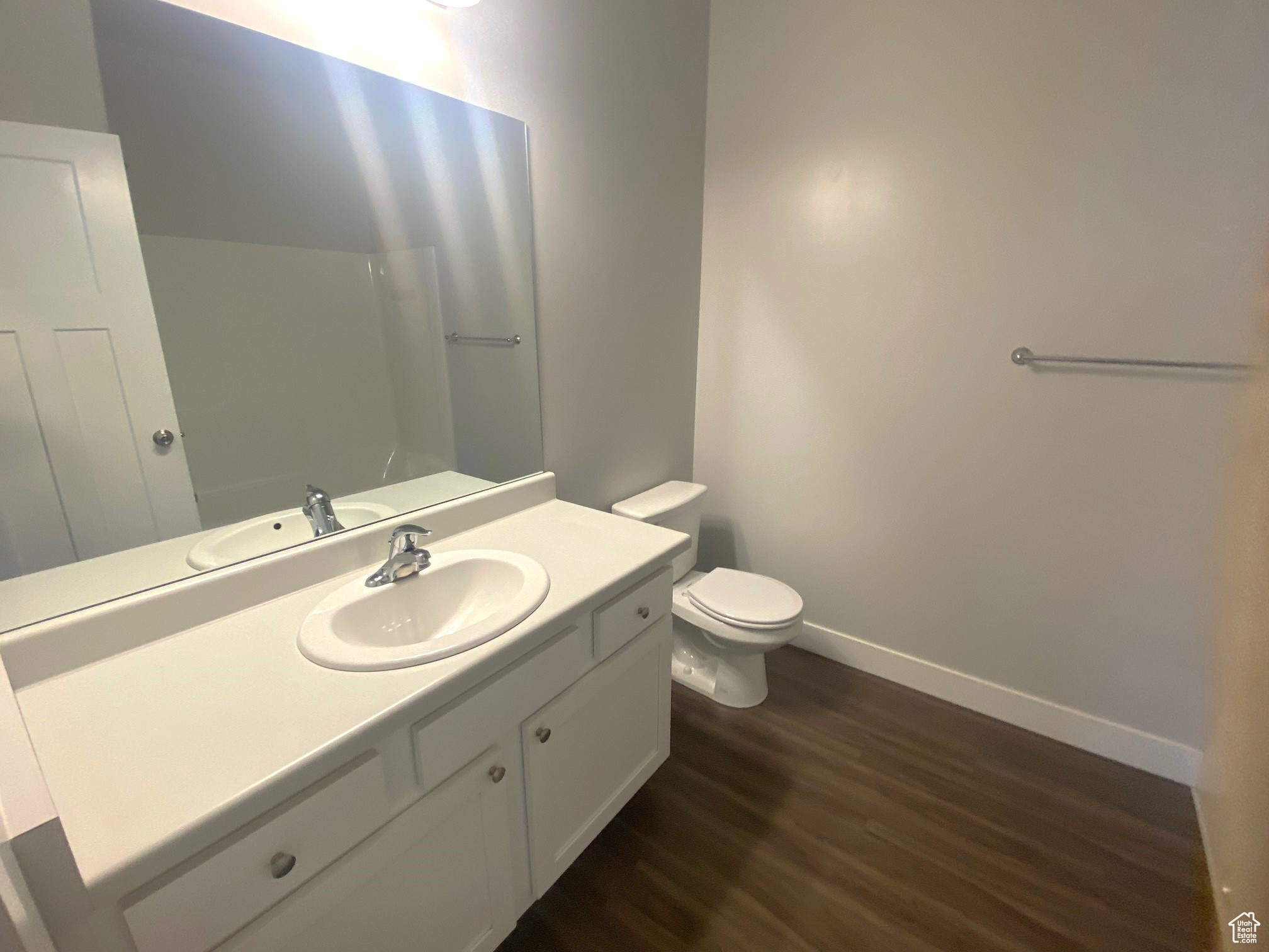 Bathroom with vanity, toilet, and wood-type flooring