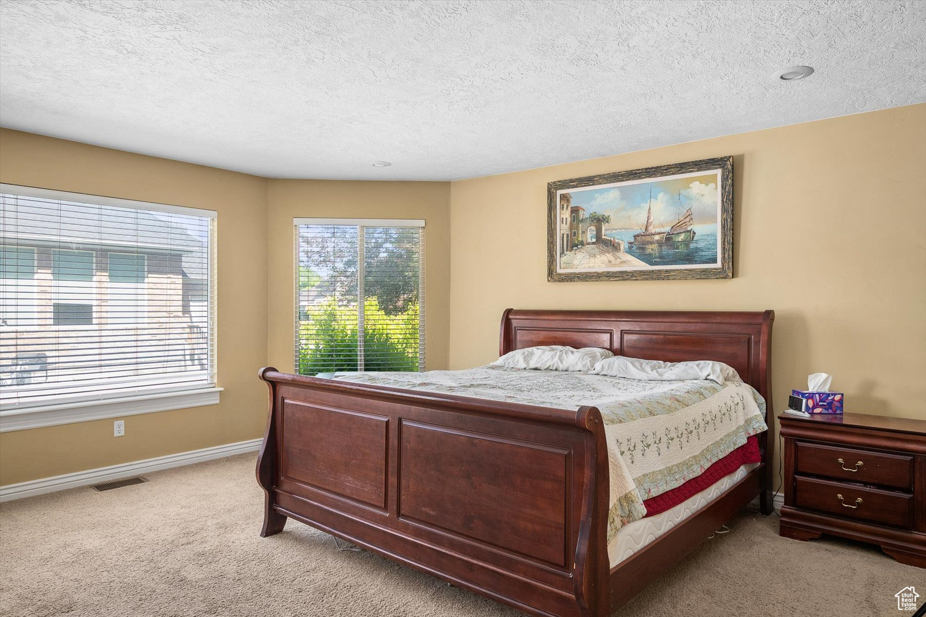 Primary Bedroom with a textured ceiling and light carpet