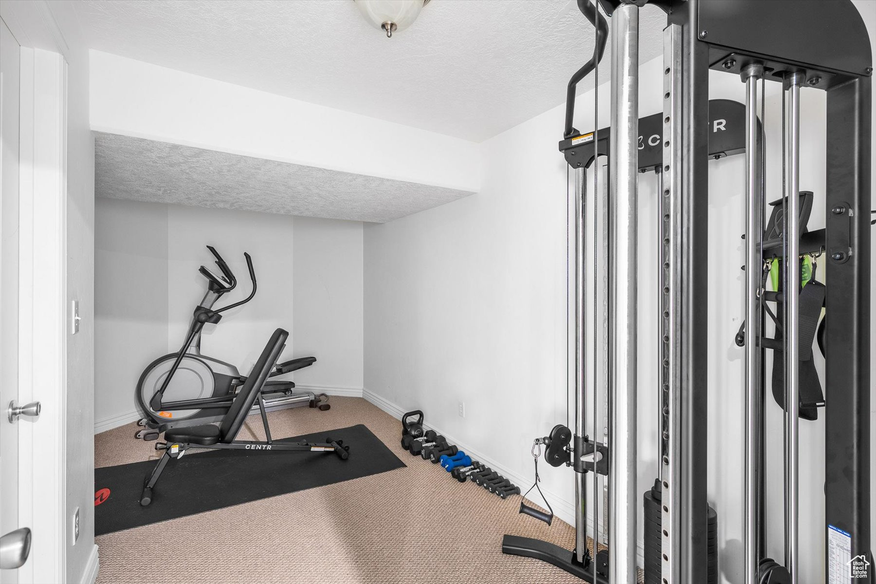 Workout area featuring a textured ceiling and carpet floors