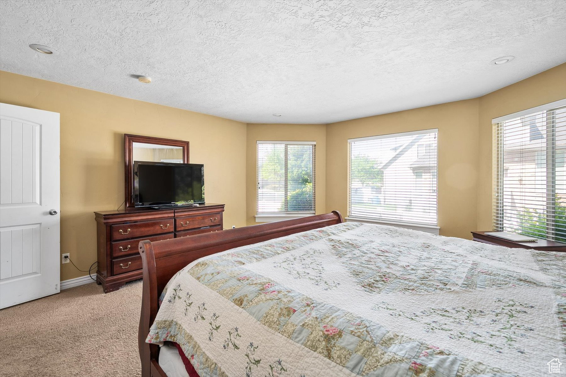 Carpeted bedroom with a textured ceiling