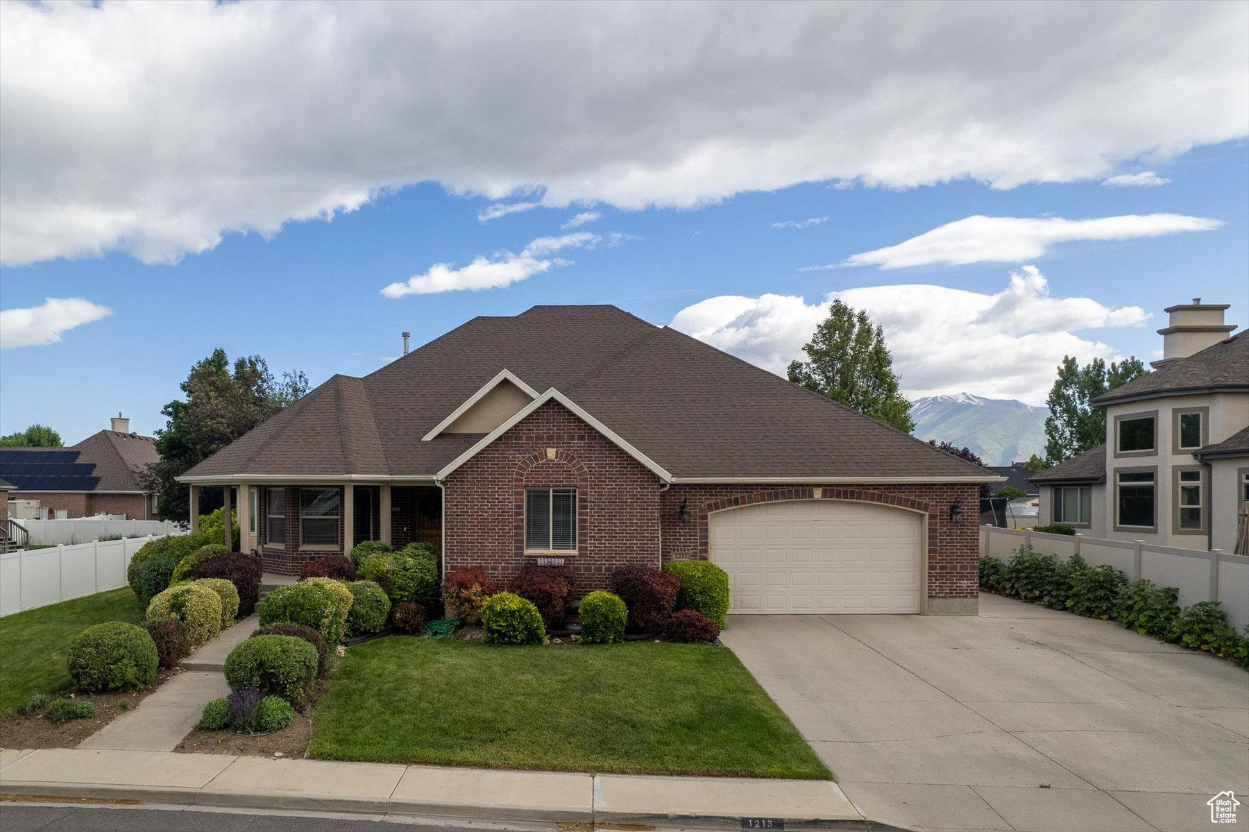 View of front of home featuring a garage, a front yard, and a mountain view