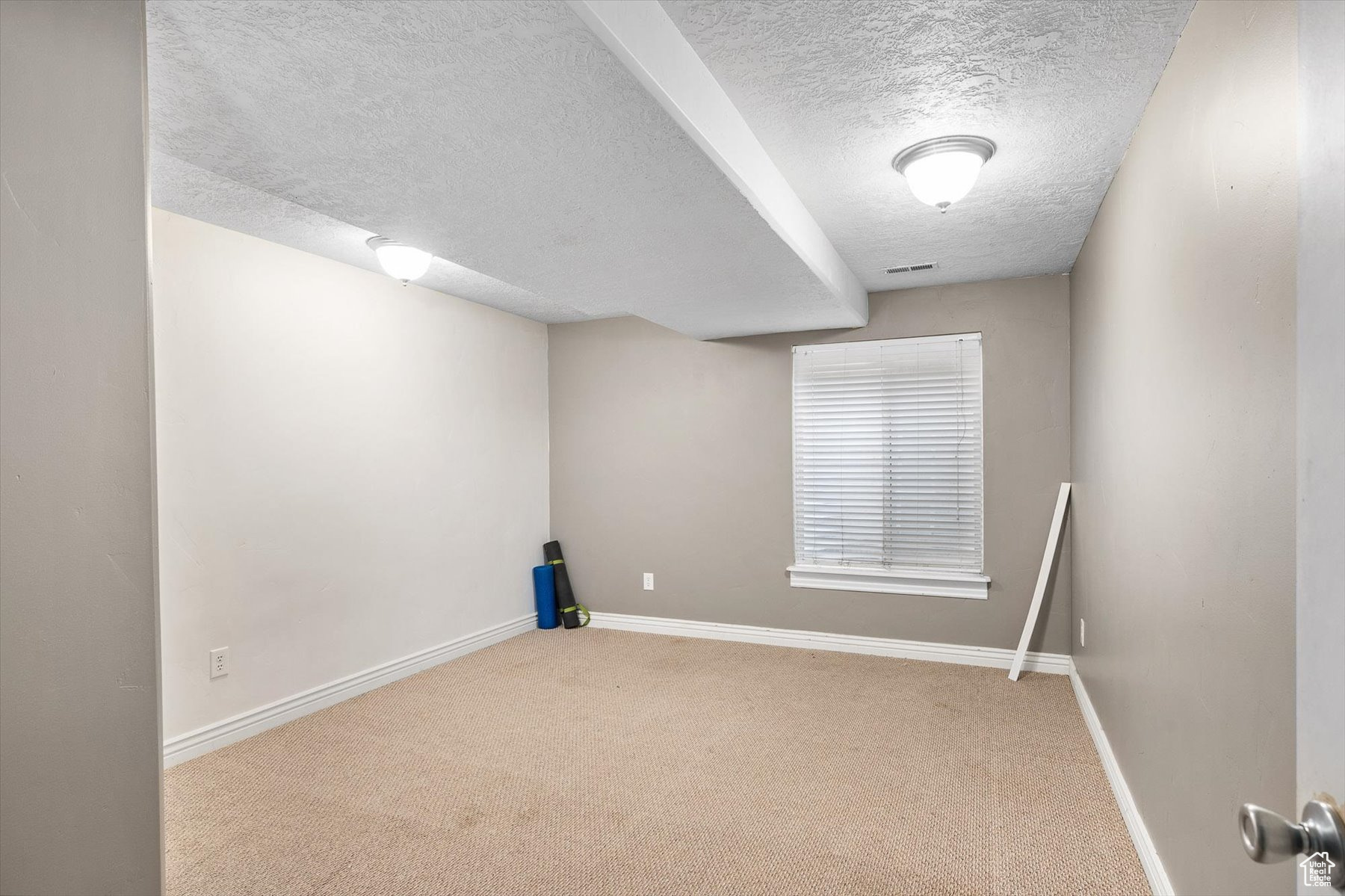 Spare room featuring a textured ceiling and carpet flooring