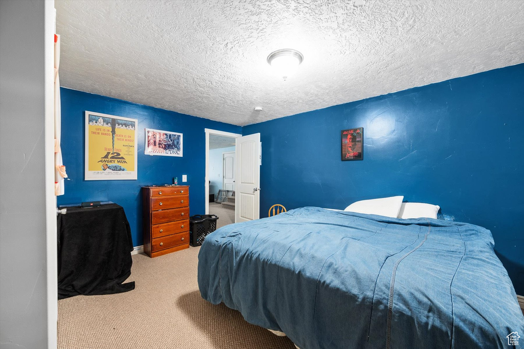 Bedroom with a textured ceiling and carpet flooring