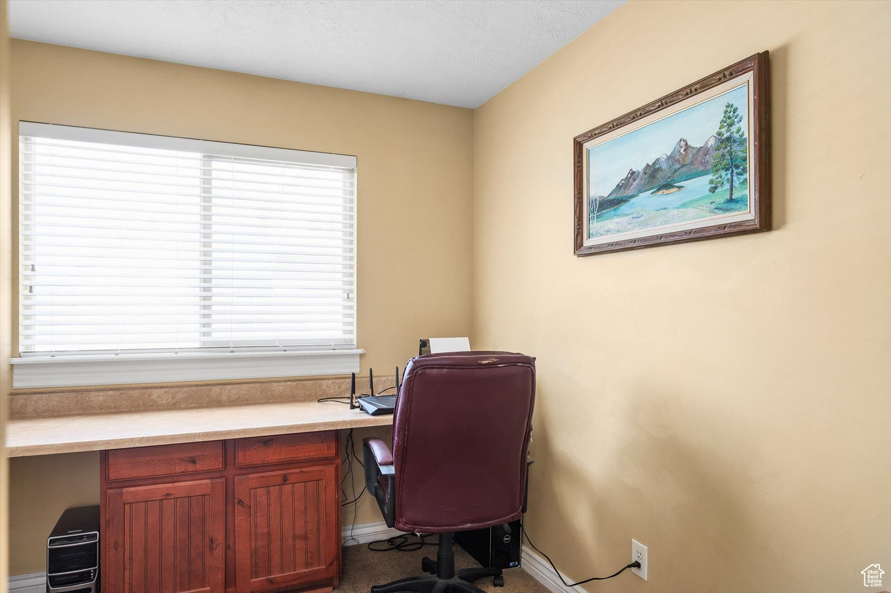 Carpeted home office featuring a healthy amount of sunlight and built in desk