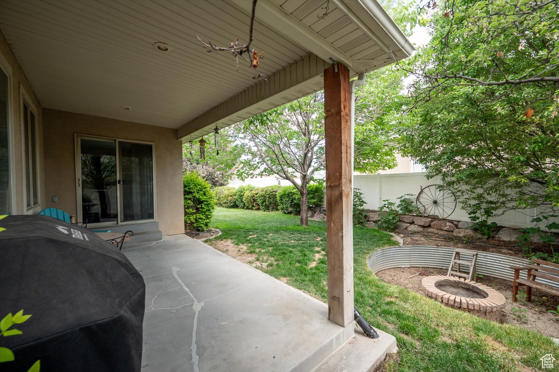 View of back patio featuring area for grilling and a fire pit where the Trampoline used to be.