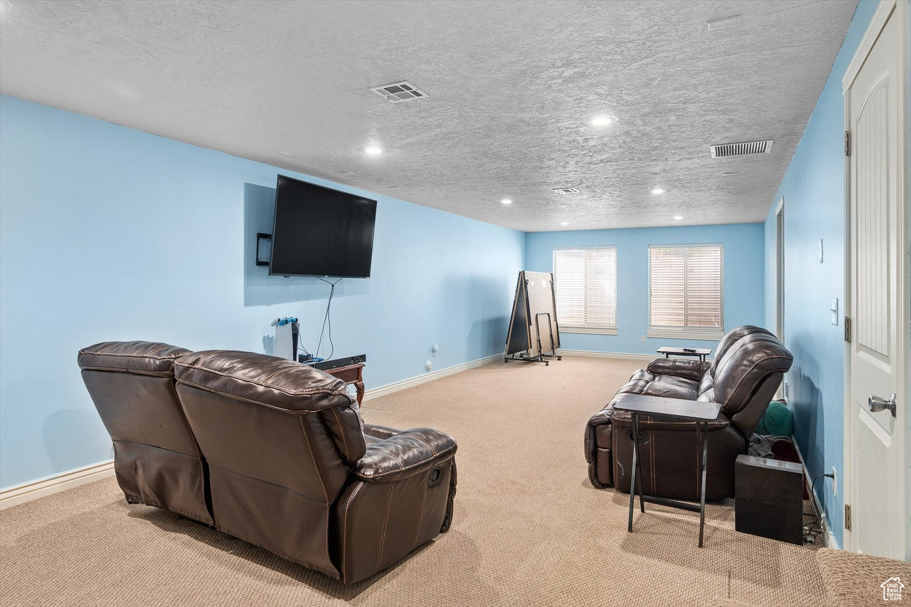 Carpeted basement living room with a textured ceiling