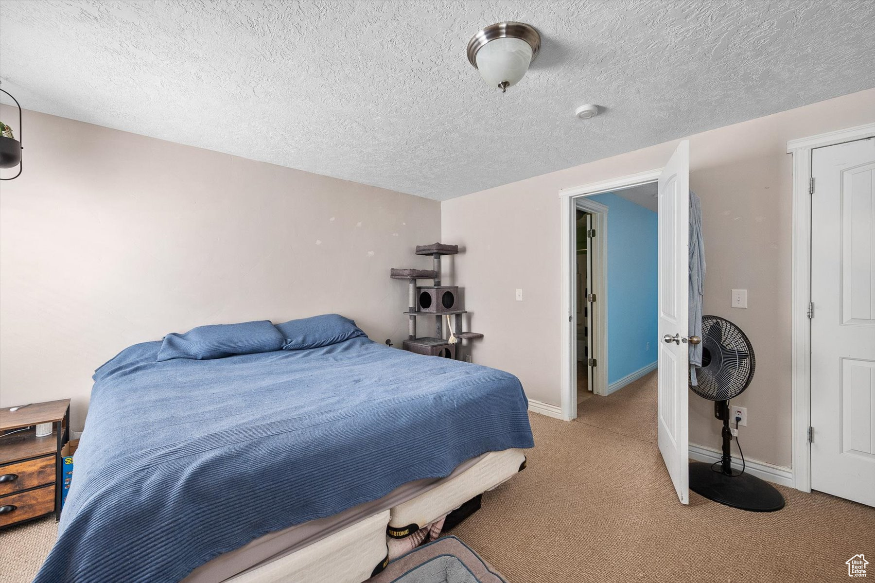 Bedroom with a textured ceiling and carpet flooring