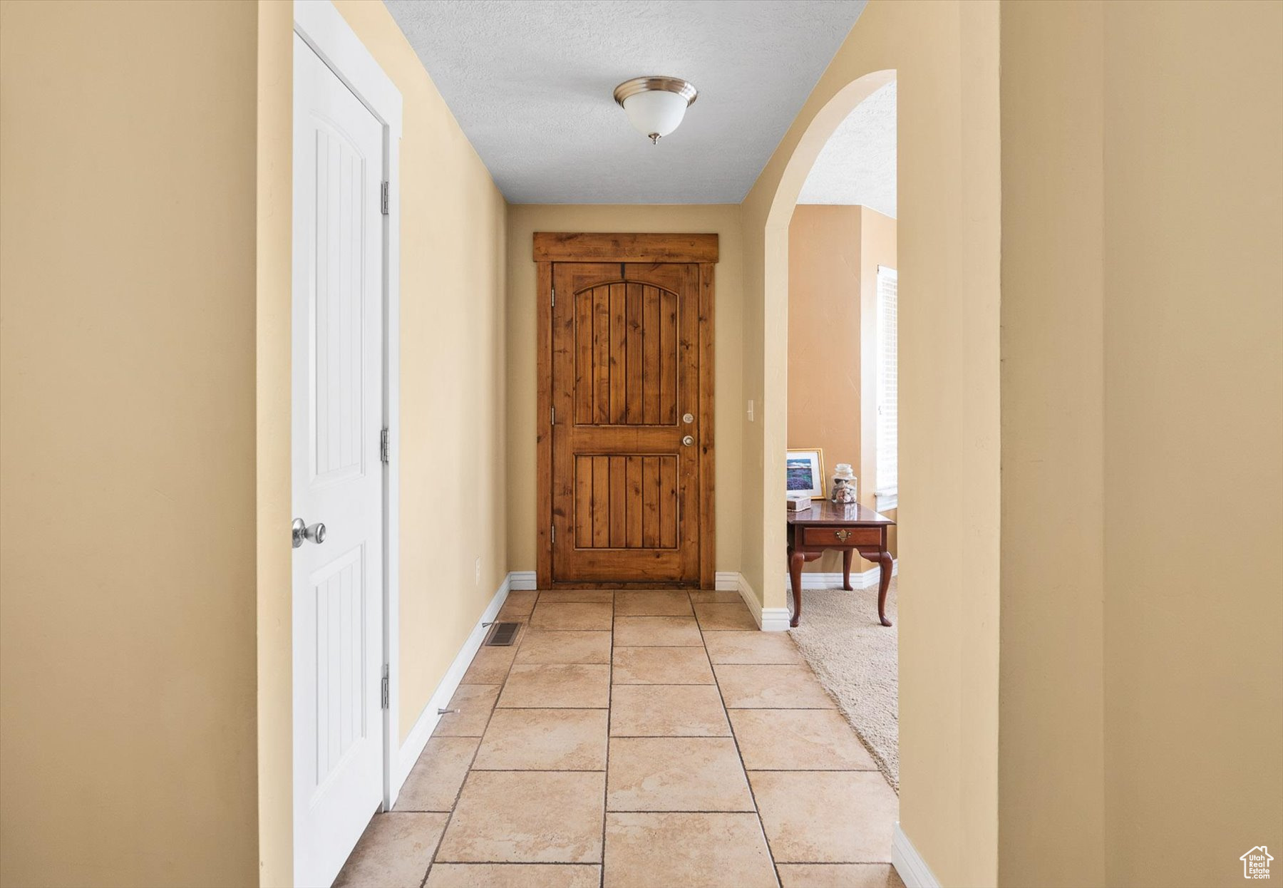 Doorway to outside with a textured ceiling and light tile flooring