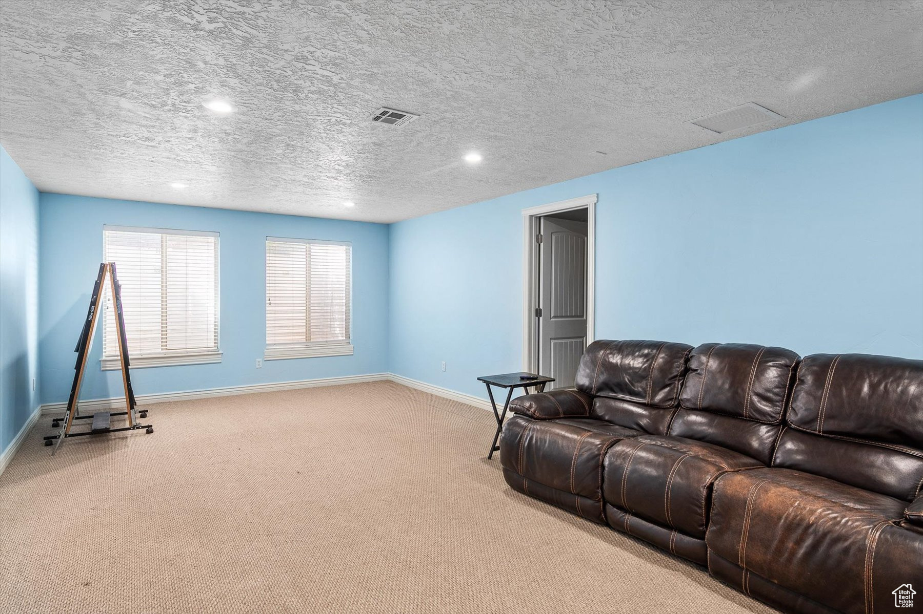 Carpeted living room featuring a textured ceiling