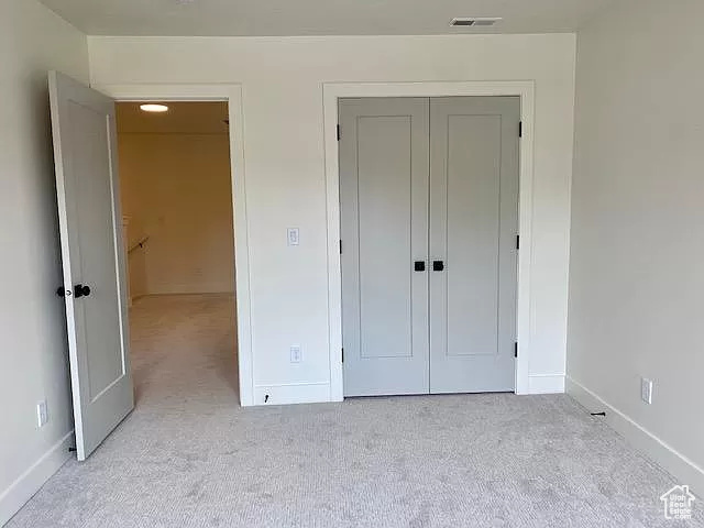 Unfurnished bedroom with light colored carpet