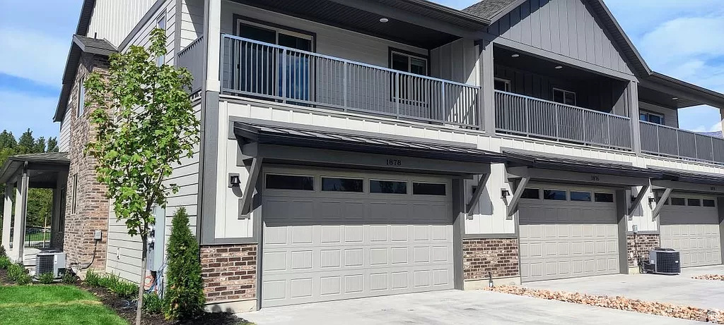 View of front facade with central air condition unit, a garage, and a balcony