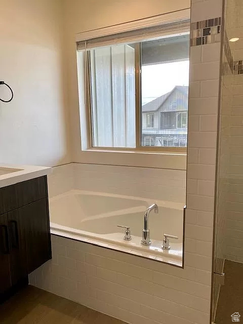 Bathroom featuring tiled bath and vanity