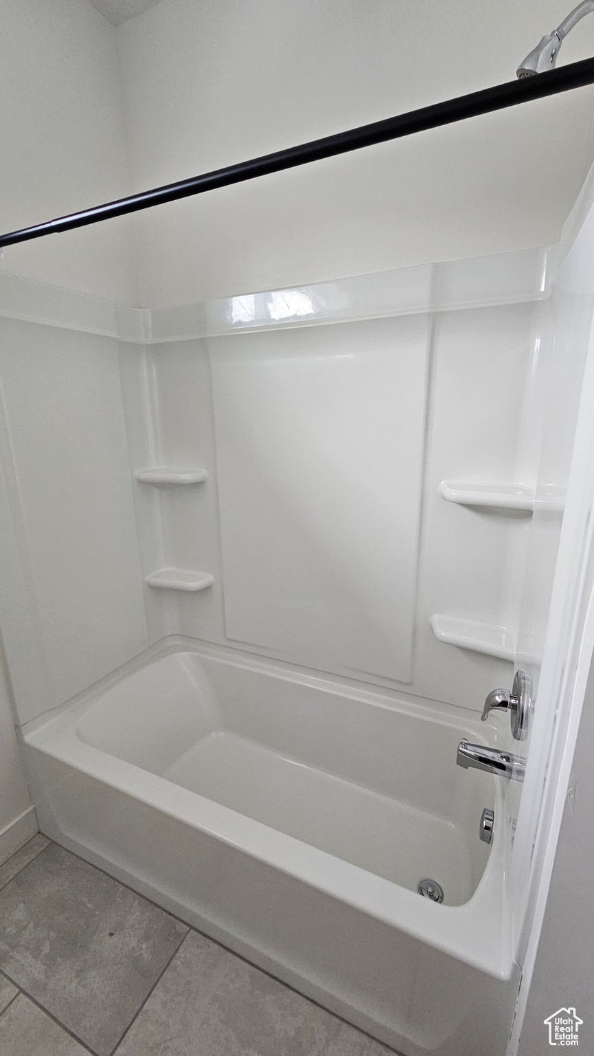 Bathroom featuring tile floors and shower / tub combination