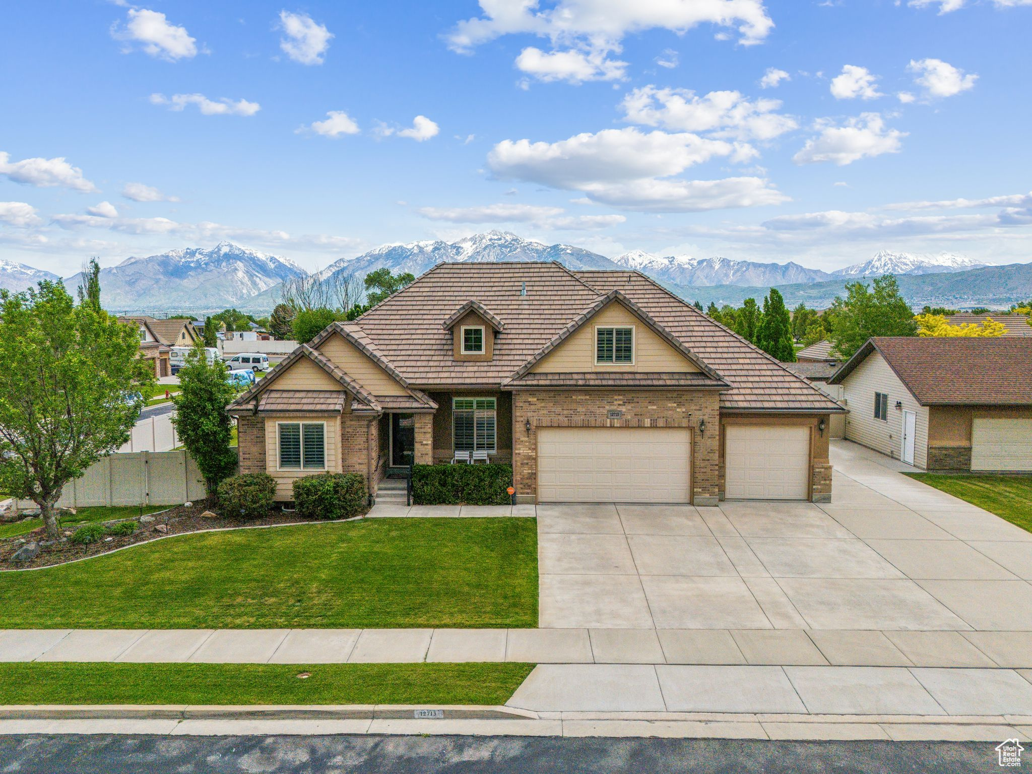 View of front of home with a garage, a front yard, and a mountain view