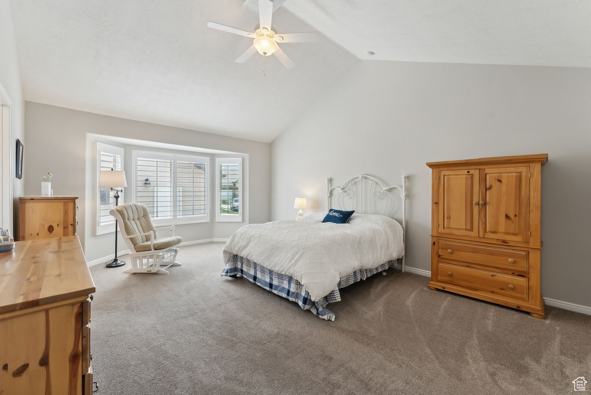 Carpeted bedroom with high vaulted ceiling and ceiling fan