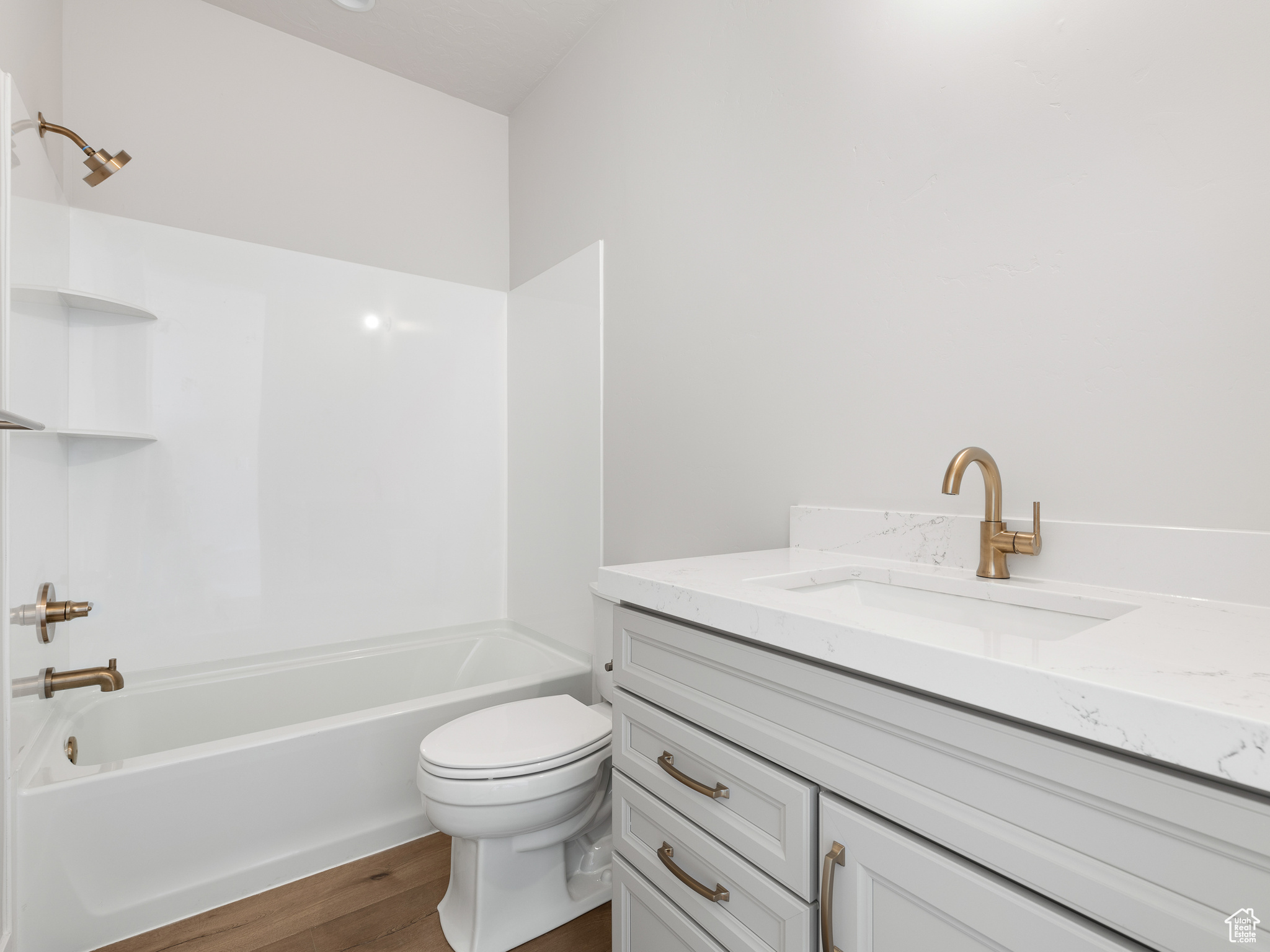 Full bathroom featuring hardwood / wood-style flooring, bathtub / shower combination, and toilet. This is a picture of Helena model home. Not the interior of actual home.