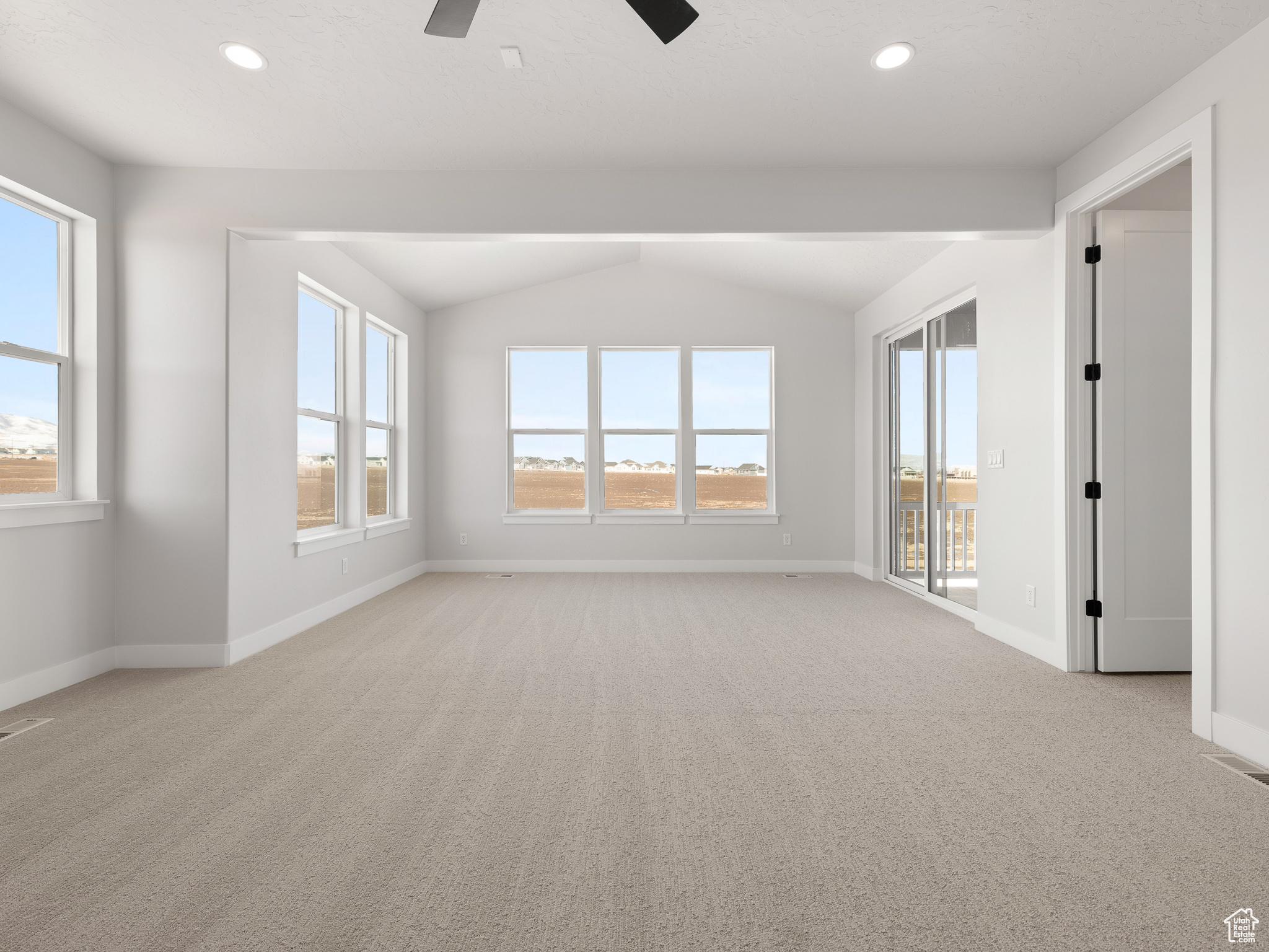 Unfurnished room with ceiling fan, vaulted ceiling, and light colored carpet. This is a picture of Helena model home. Not the interior of actual home.