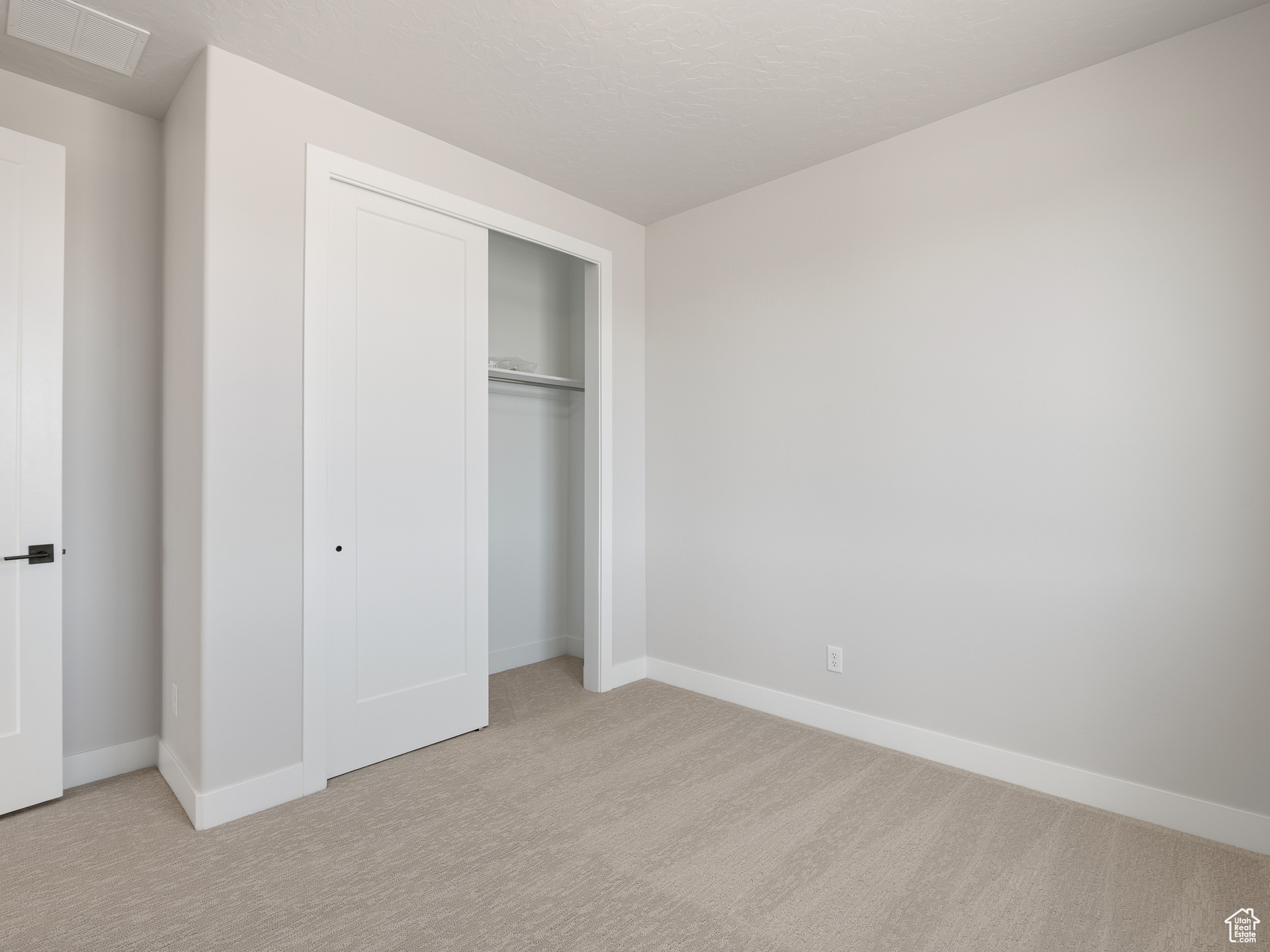 Unfurnished bedroom featuring light colored carpet and a closet. This is a picture of Helena model home. Not the interior of actual home.