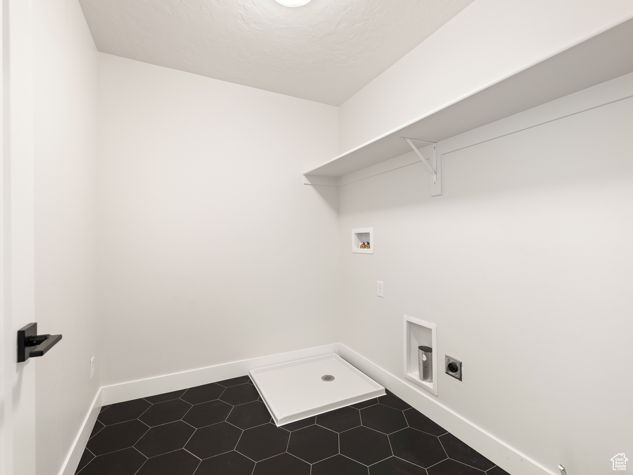 Laundry area with electric dryer hookup, tile flooring, and washer hookup. This is a picture of Helena model home. Not the interior of actual home.