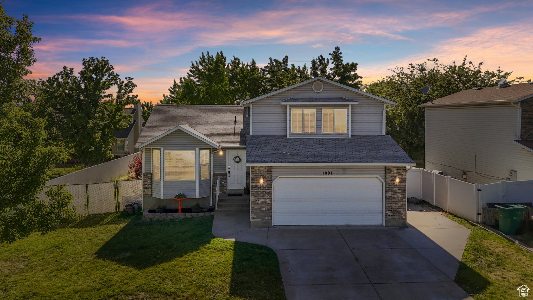 View of front of house with a garage and a lawn