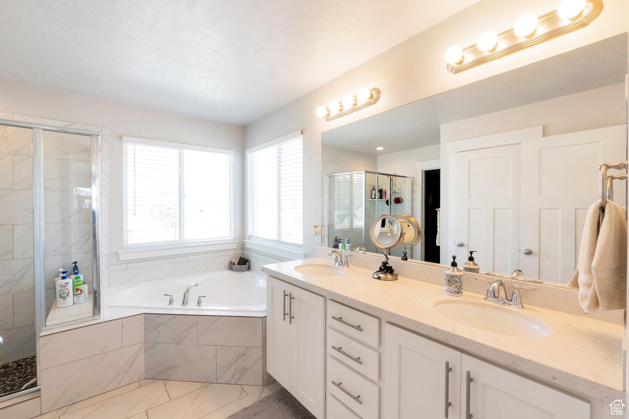 Bathroom featuring independent shower and bath, double sink vanity, and tile flooring