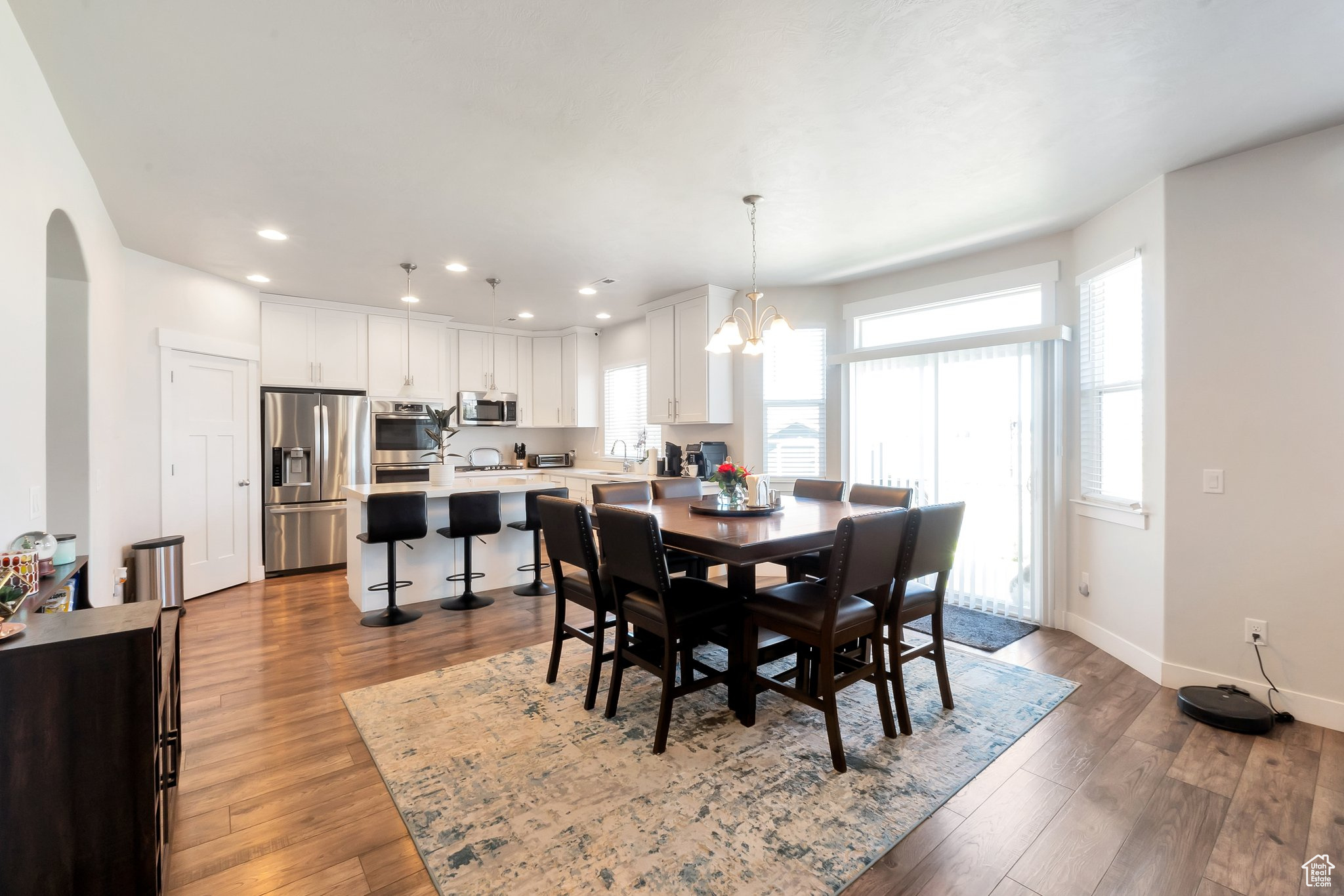 Dining room featuring sink, a chandelier, and light hardwood / wood-style flooring