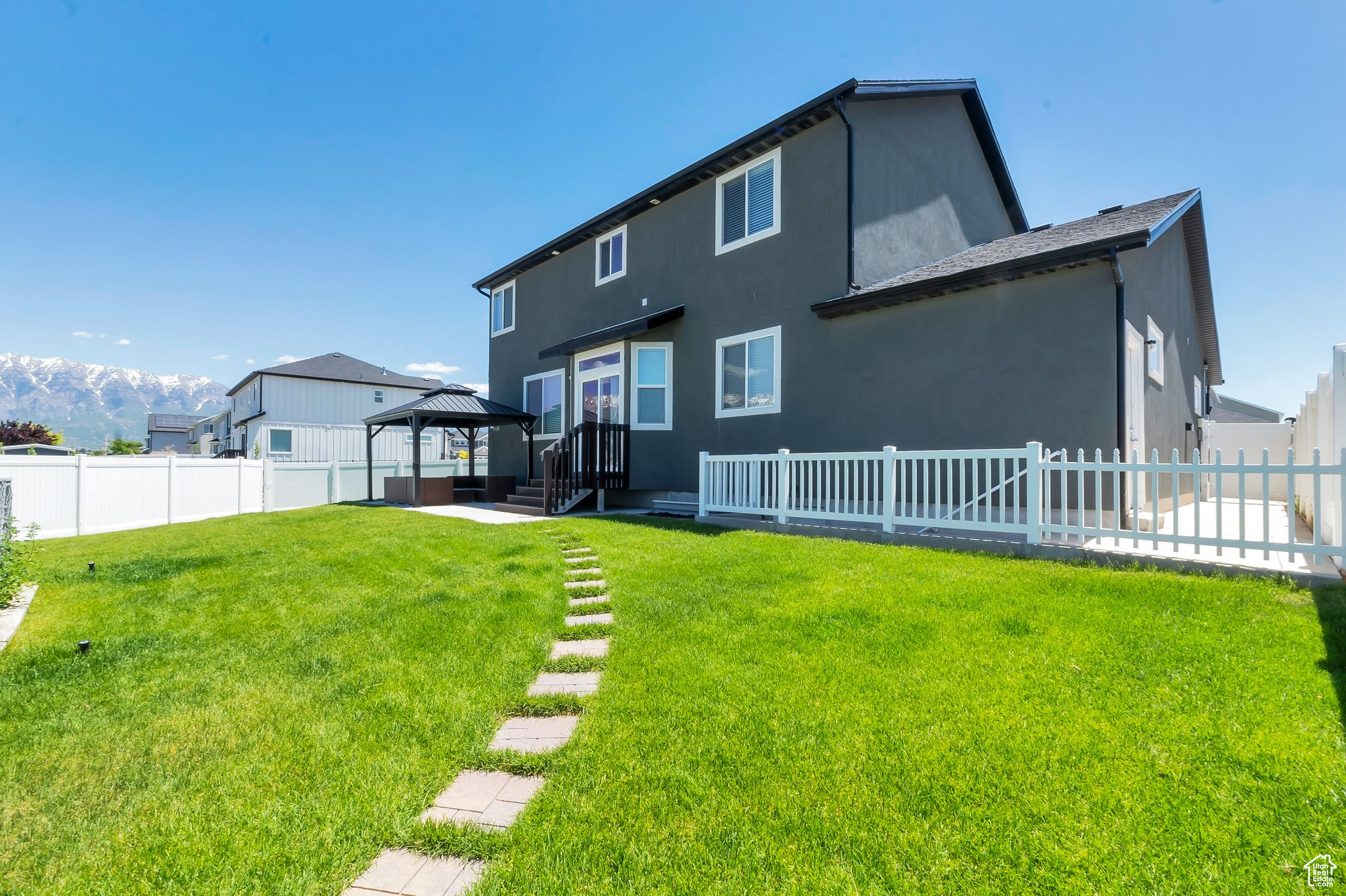 Back of house featuring a yard and a gazebo