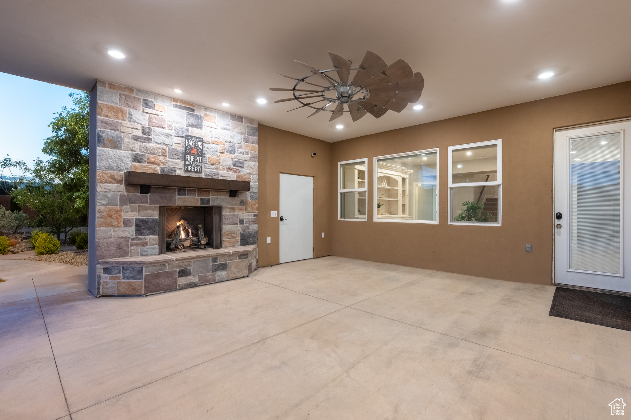 Unfurnished living room featuring ceiling fan and an outdoor stone fireplace