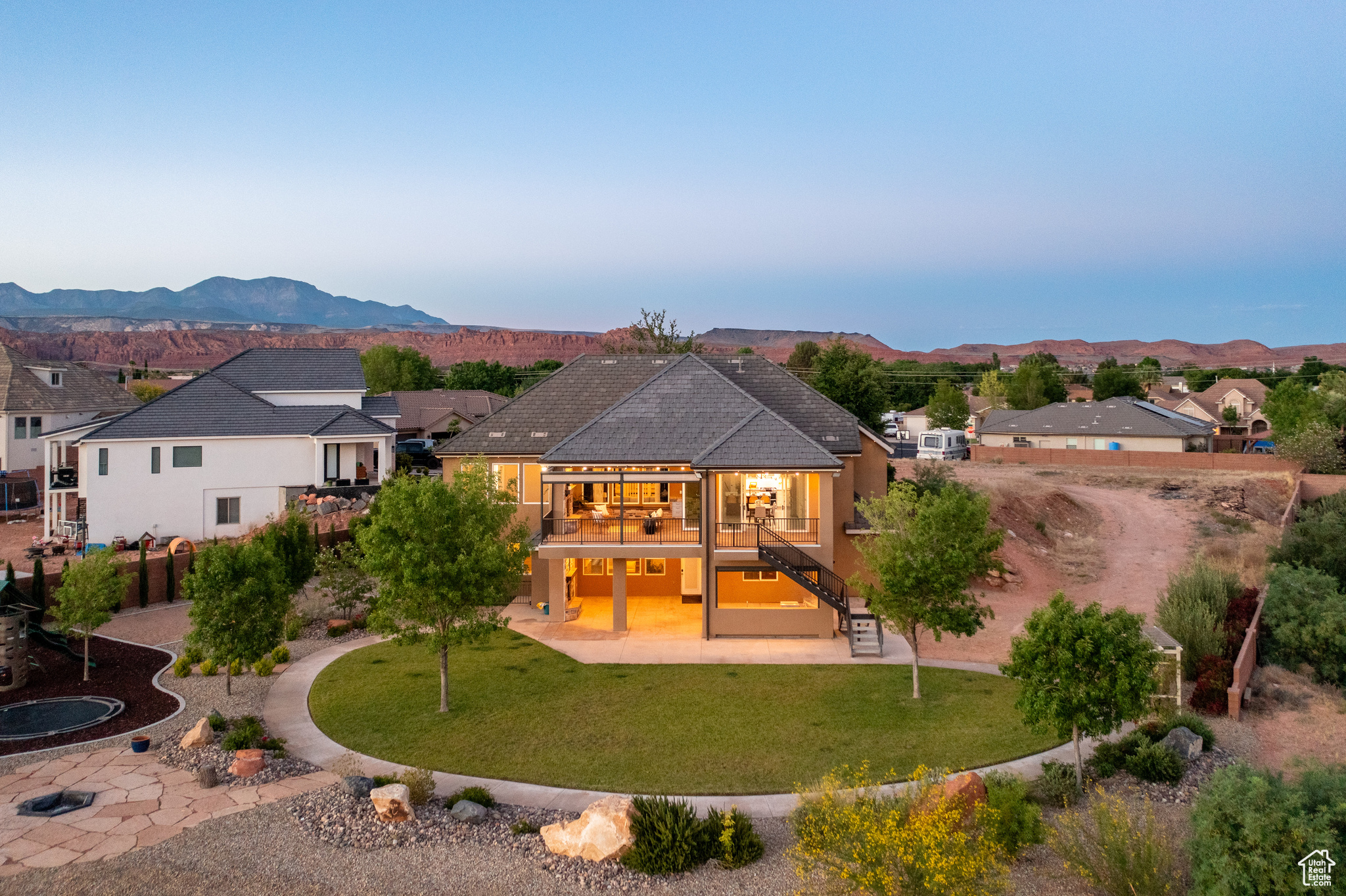 Rear view of property with a patio, an outdoor living space, a mountain view, and a lawn