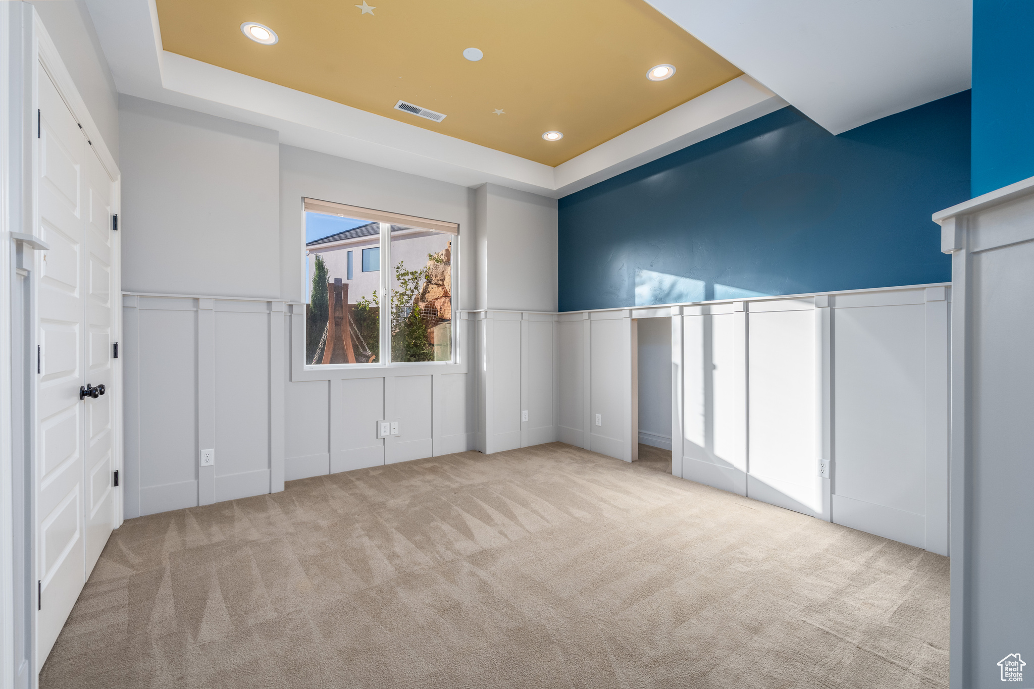 Interior space with light colored carpet and a raised ceiling