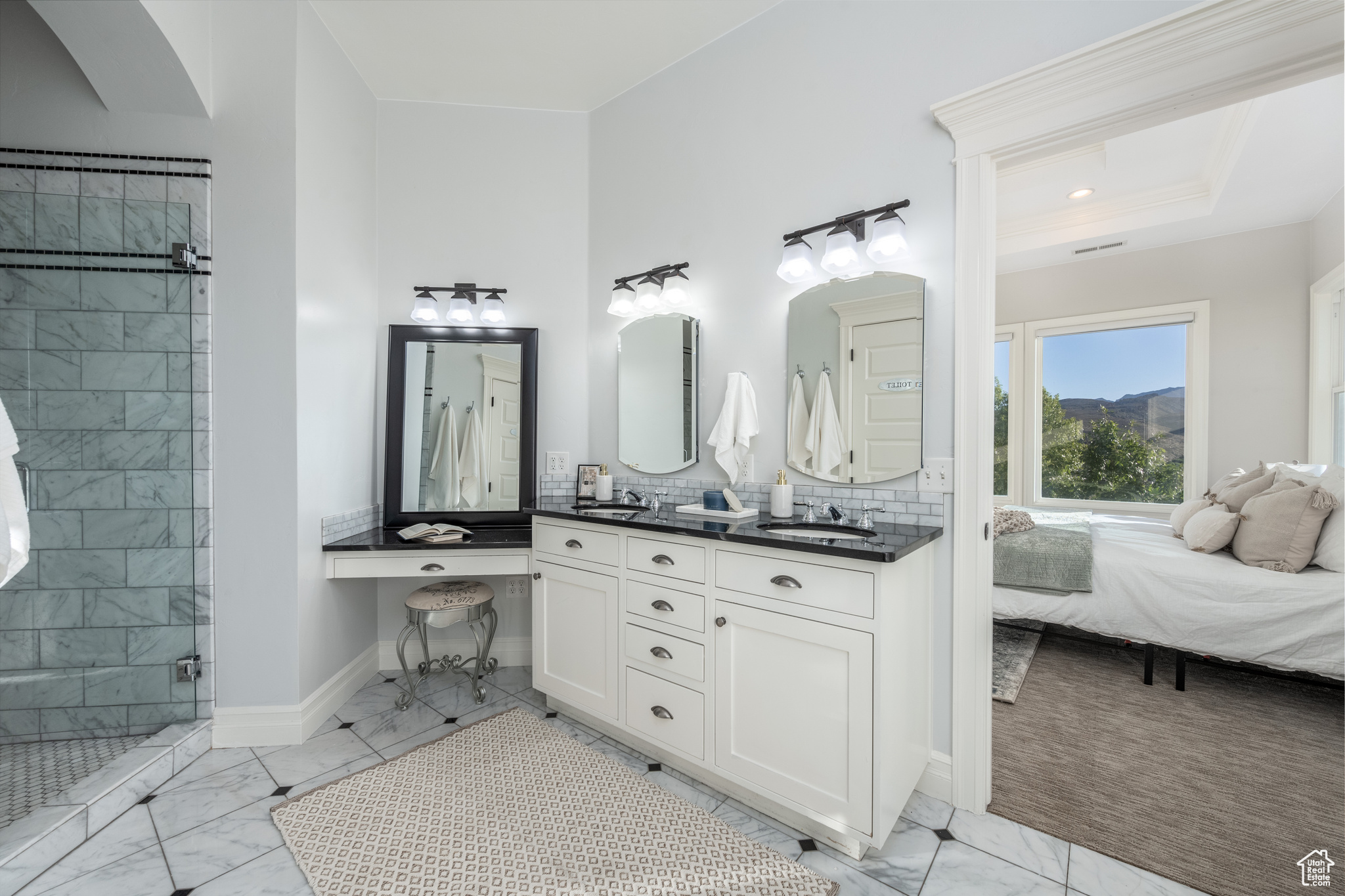 Bathroom with dual sinks, tasteful backsplash, a raised ceiling, a tile shower, and large vanity