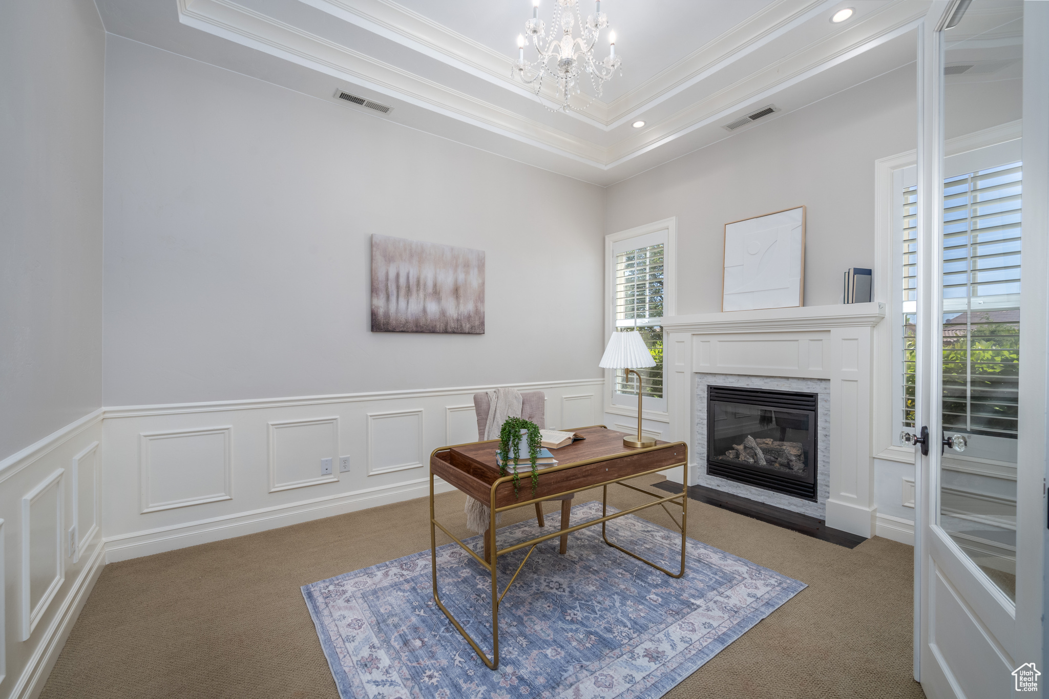 Office with an inviting chandelier, a tray ceiling, carpet floors, and crown molding