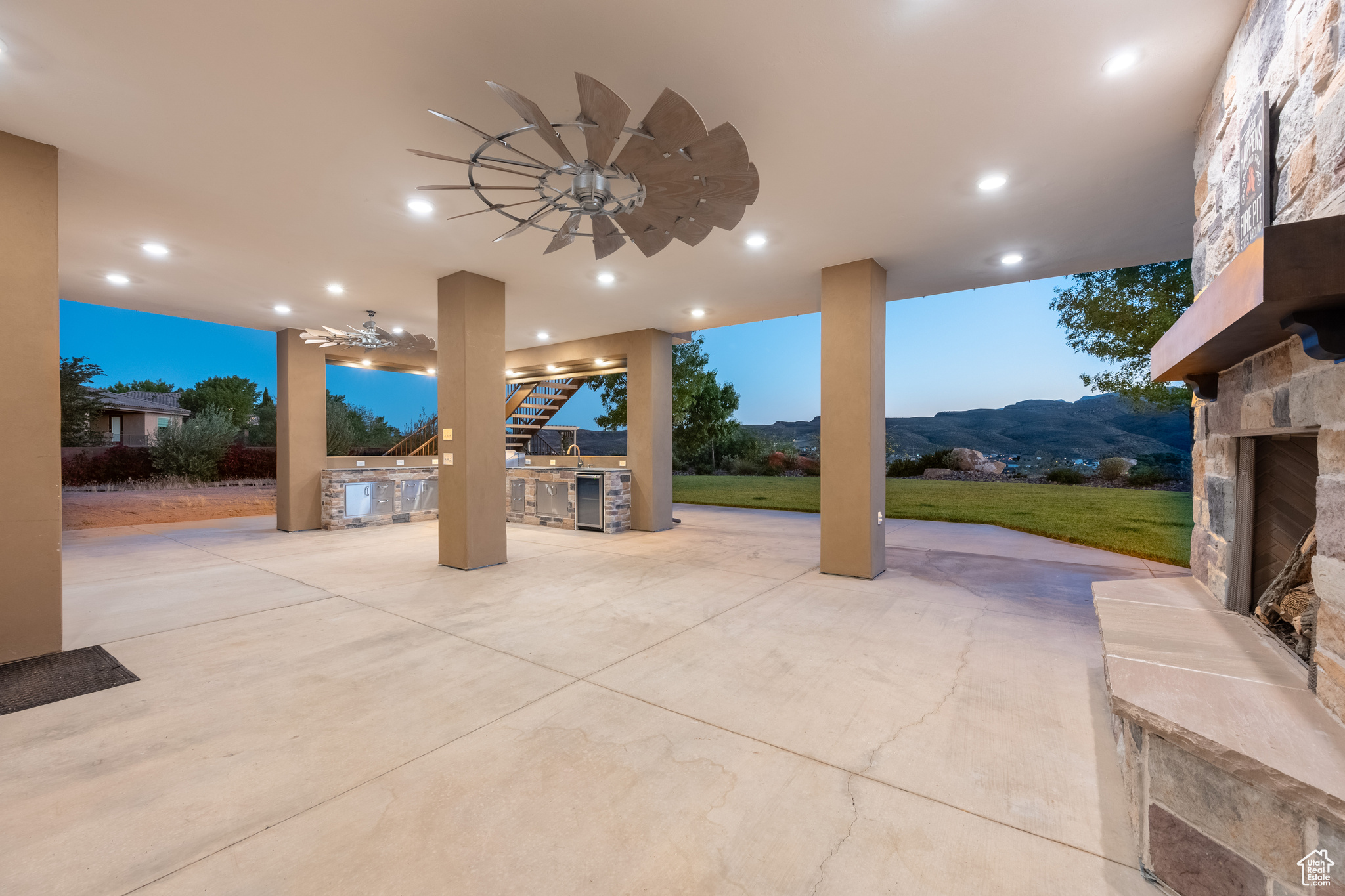 View of patio with area for grilling, an outdoor stone fireplace, and a mountain view