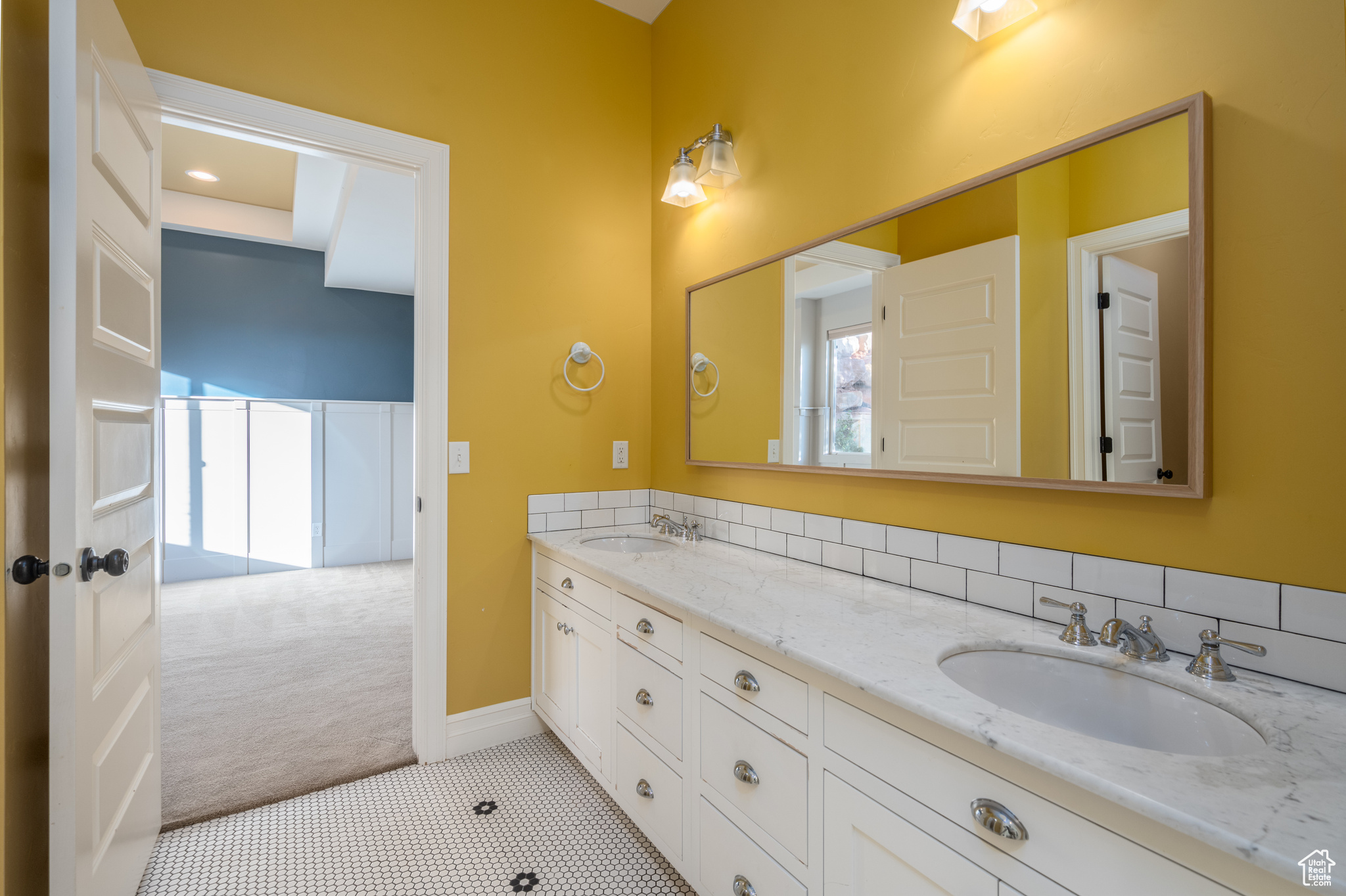 Bathroom with tile floors, backsplash, oversized vanity, and dual sinks