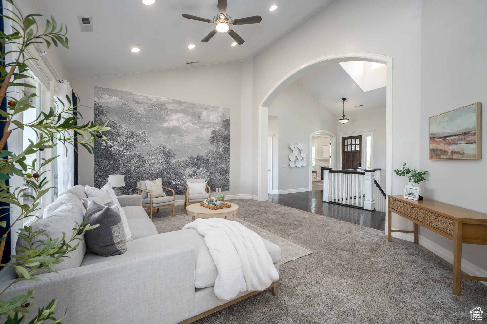 Living room with high vaulted ceiling, dark wood-type flooring, and ceiling fan