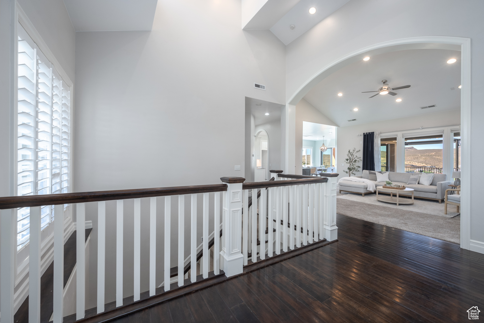 Hallway featuring high vaulted ceiling and dark hardwood / wood-style floors