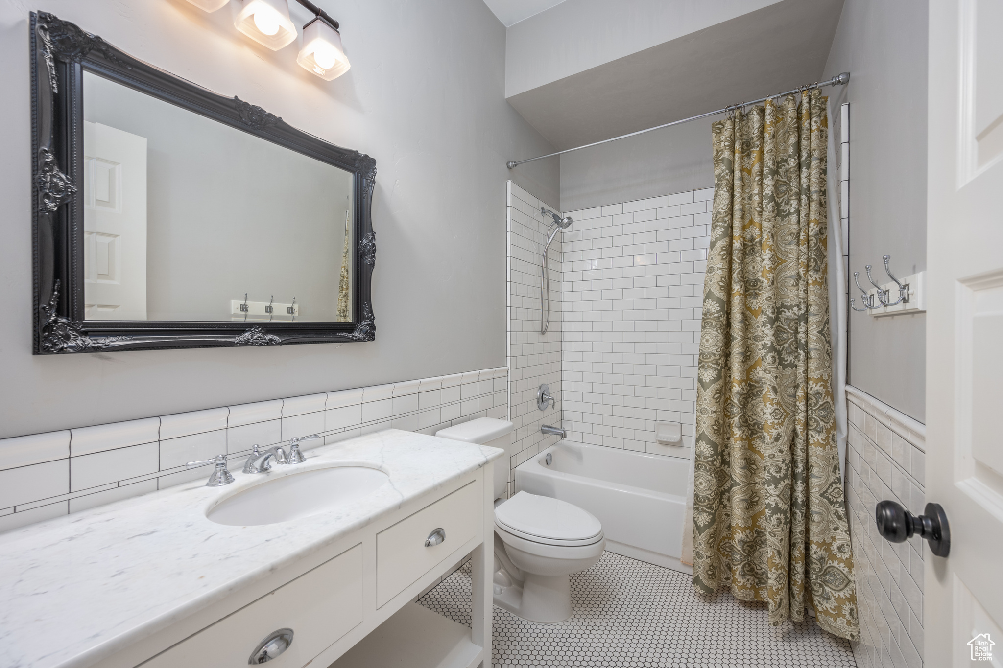 Full bathroom featuring tile walls, tile flooring, large vanity, and toilet