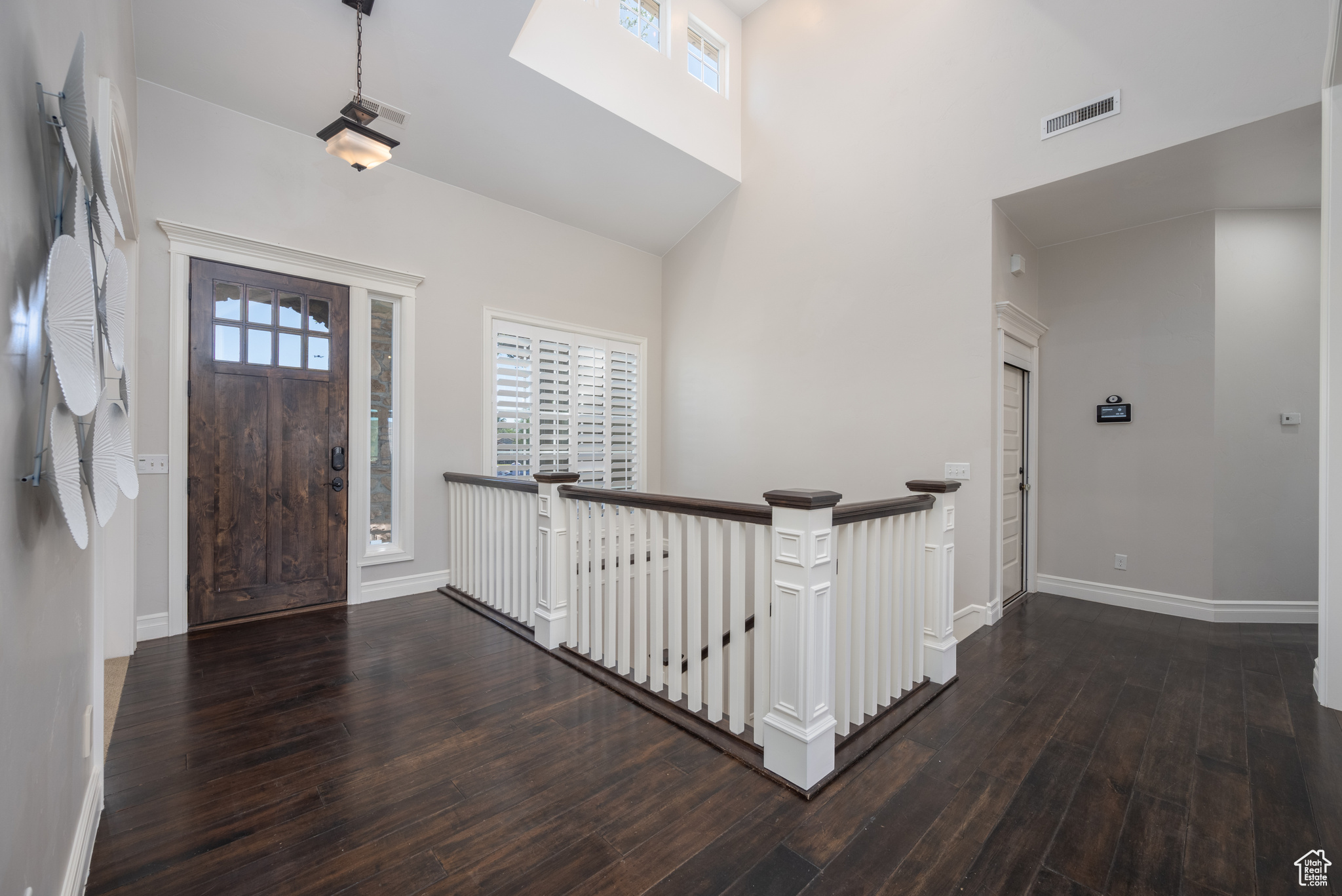 Entrance foyer with vaulted ceiling and dark hardwood / wood-style flooring