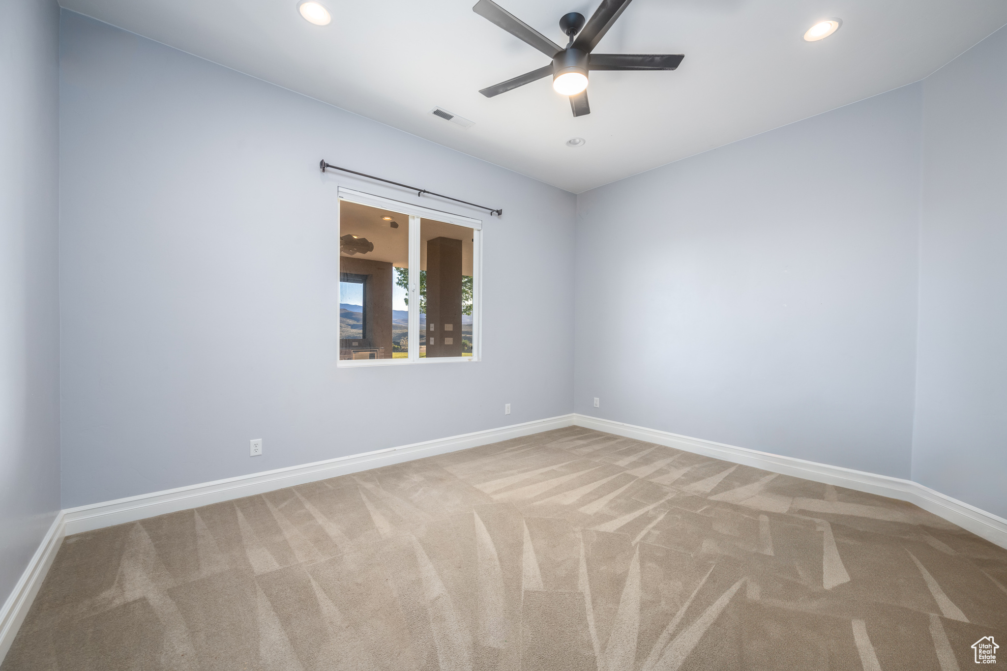 Carpeted spare room with ceiling fan