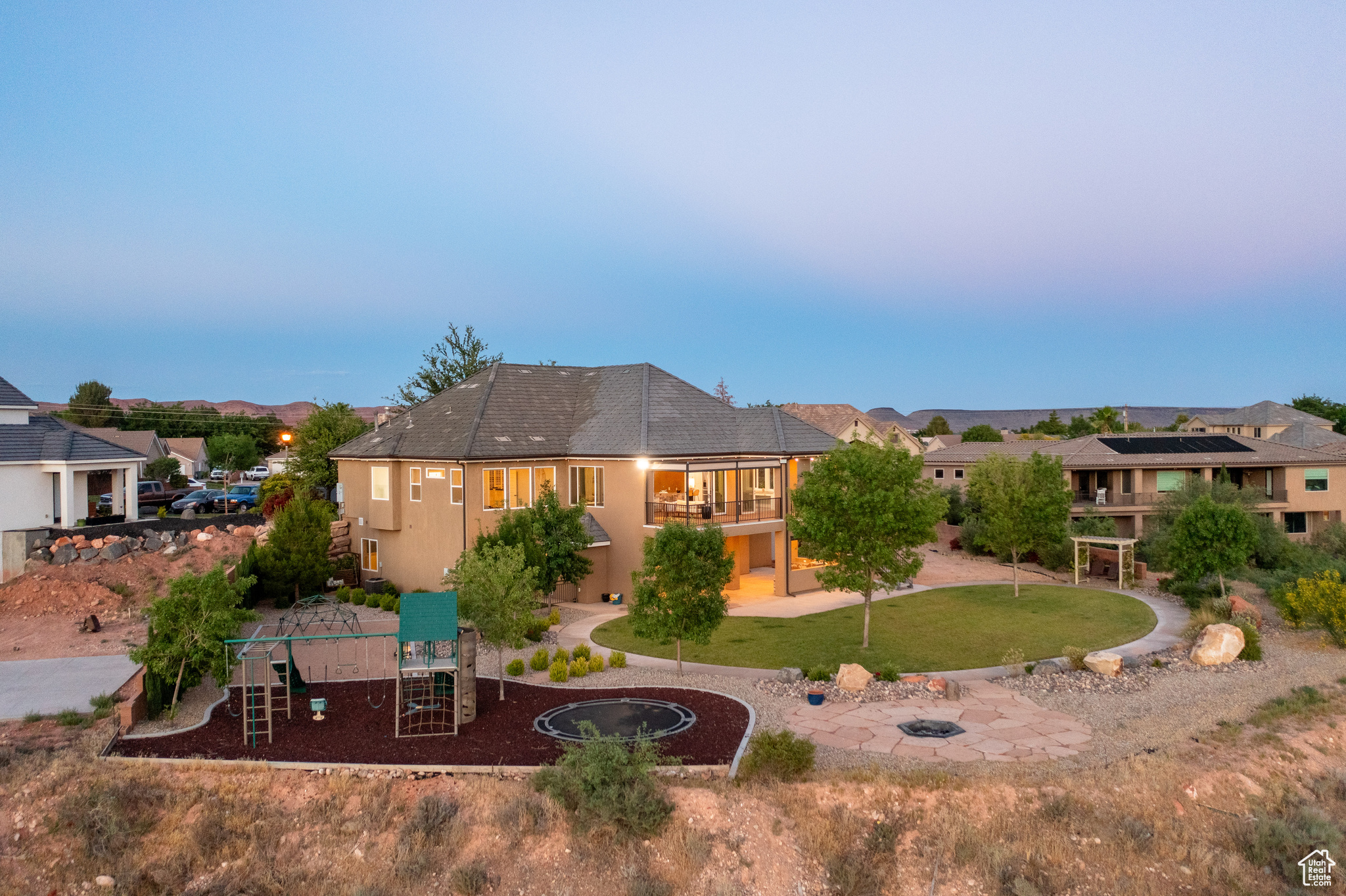 Rear view of property featuring a playground, solar panels, and a balcony