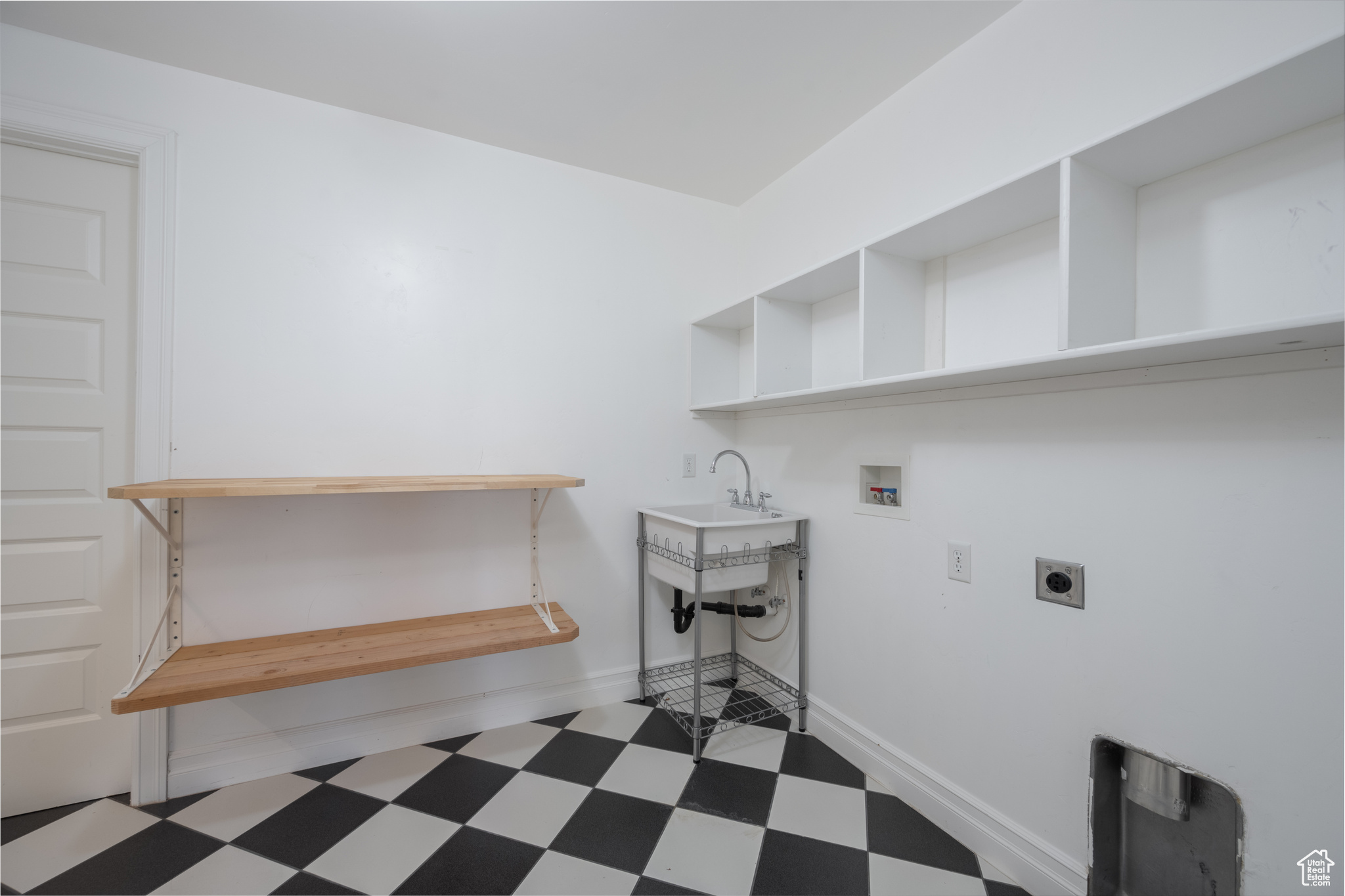 Washroom with electric dryer hookup, dark tile flooring, and hookup for a washing machine