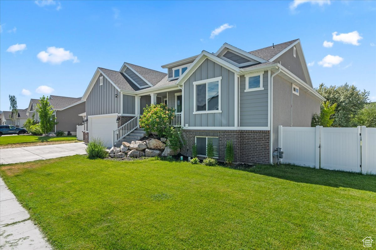 View of front of property featuring a garage and a front lawn