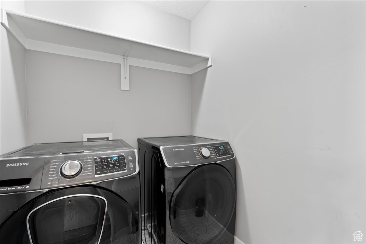 Clothes washing area featuring independent washer and dryer and washer hookup