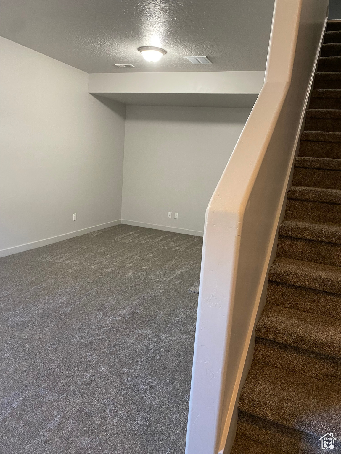 Interior space with a textured ceiling and carpet floors