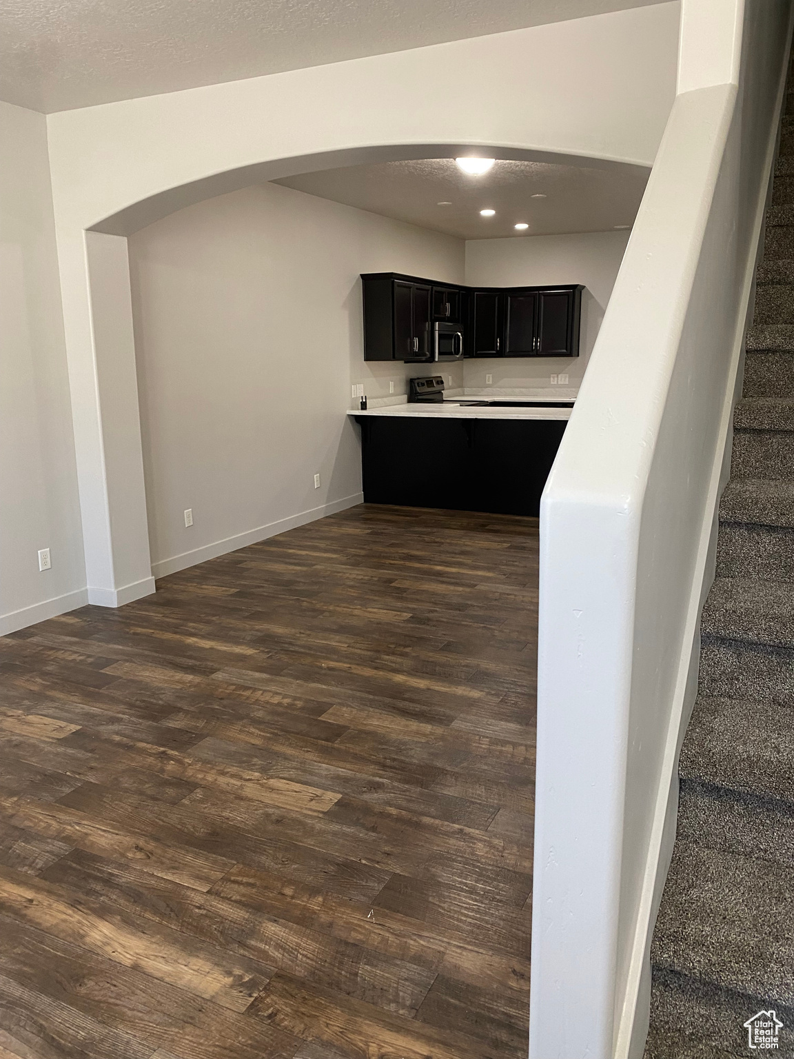 Interior space with a textured ceiling and dark hardwood / wood-style flooring